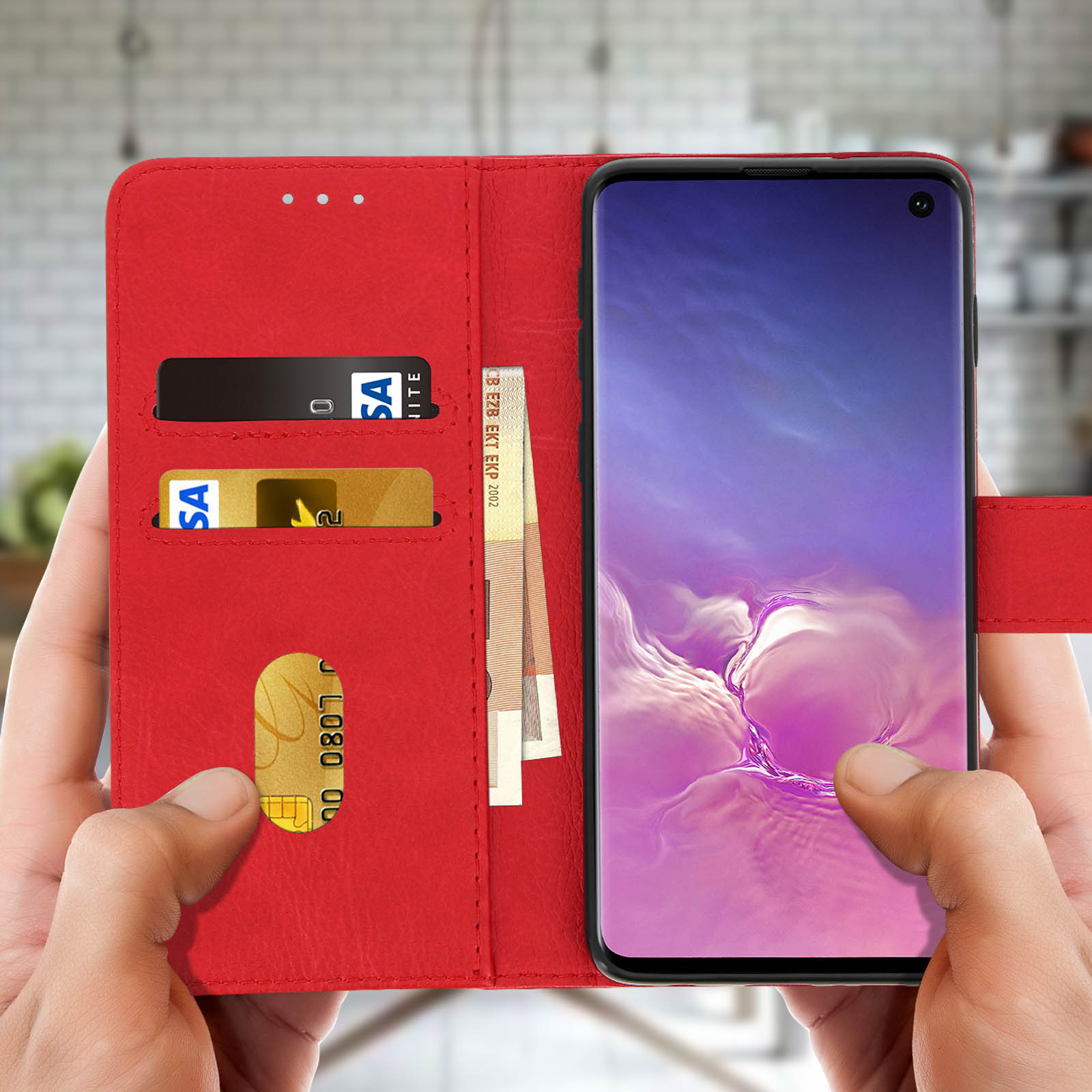 Custodia rossa per telefono con carte e telefono. Mani che tengono la custodia. Sfondo sfocato.