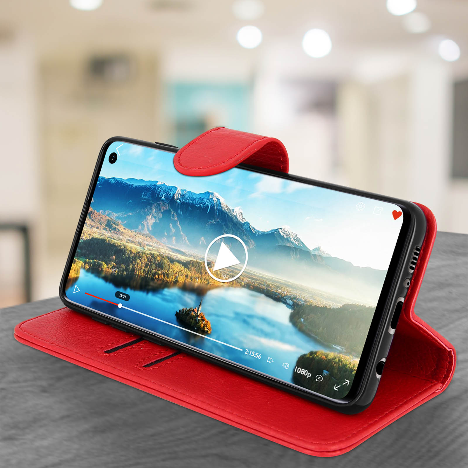 Custodia per telefono rossa con un telefono che mostra un video. Il telefono è su un tavolo grigio.