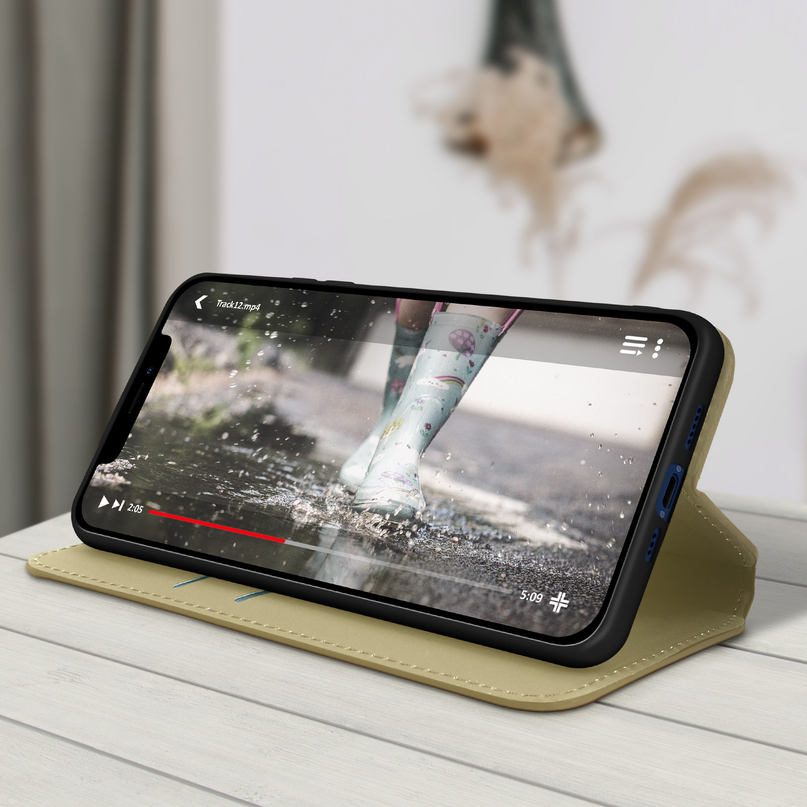 Un smartphone dans un étui affichant une vidéo d'une personne marchant dans une flaque, sur une surface en bois.