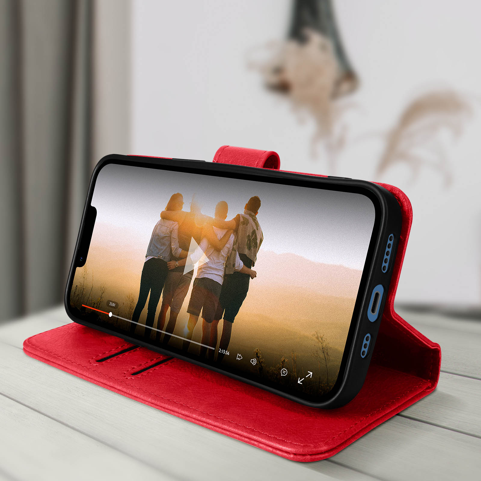 Custodia per telefono rossa con telefono che mostra un video di persone. Custodia su una superficie di legno.
