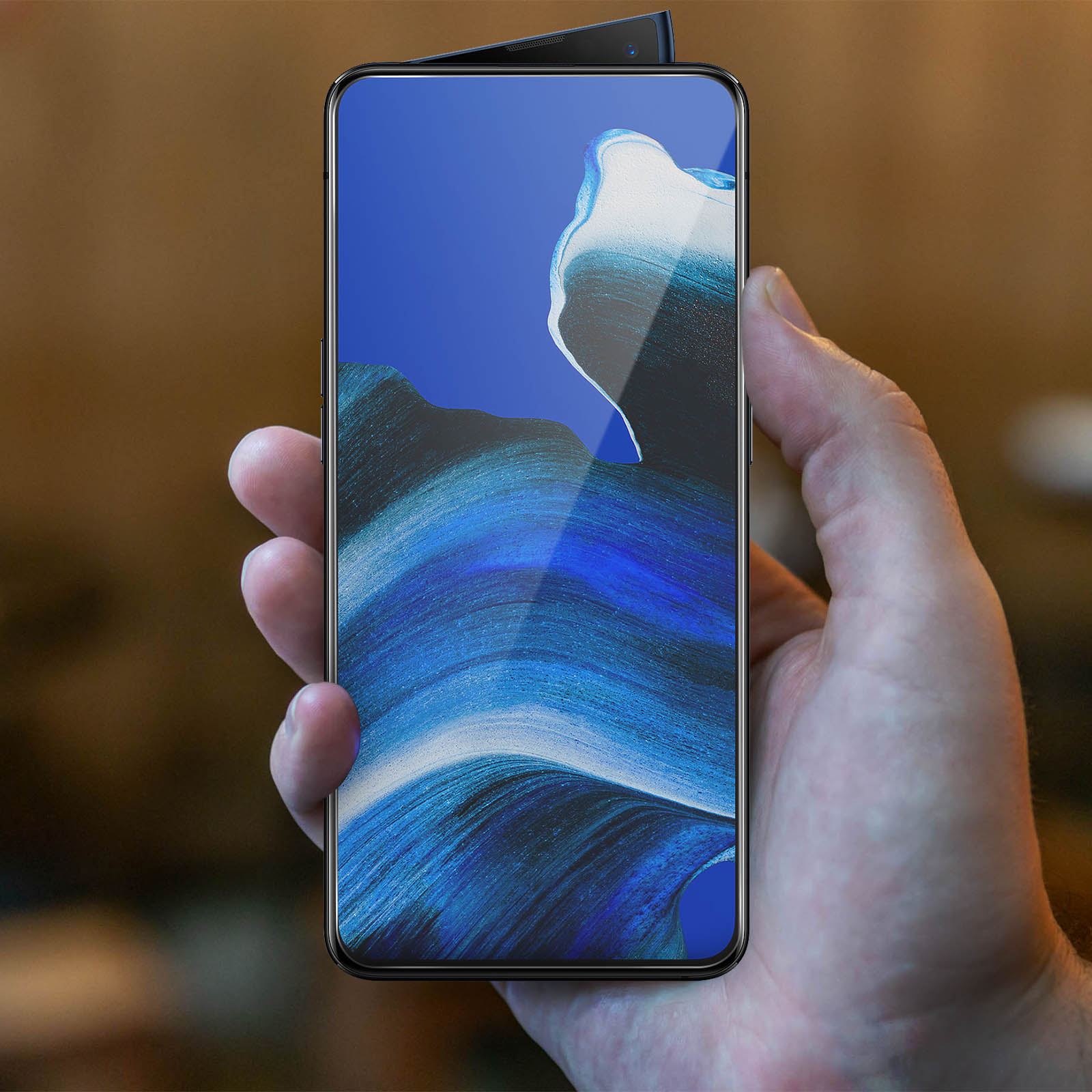 Una mano che tiene un telefono con una protezione schermo a onde blu e bianche. Il telefono è acceso.