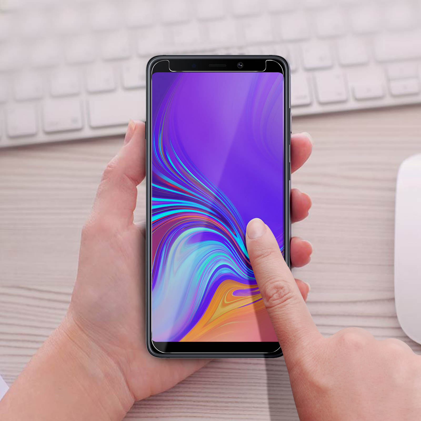 Il dito di una persona sullo schermo di un telefono con protezione. Lo schermo mostra un'interfaccia colorata.
