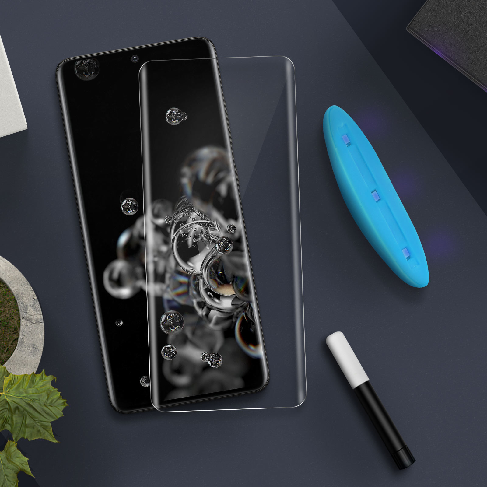 Telefono e protezione schermo con goccioline d'acqua. Una luce UV blu e un pennarello sulla superficie.