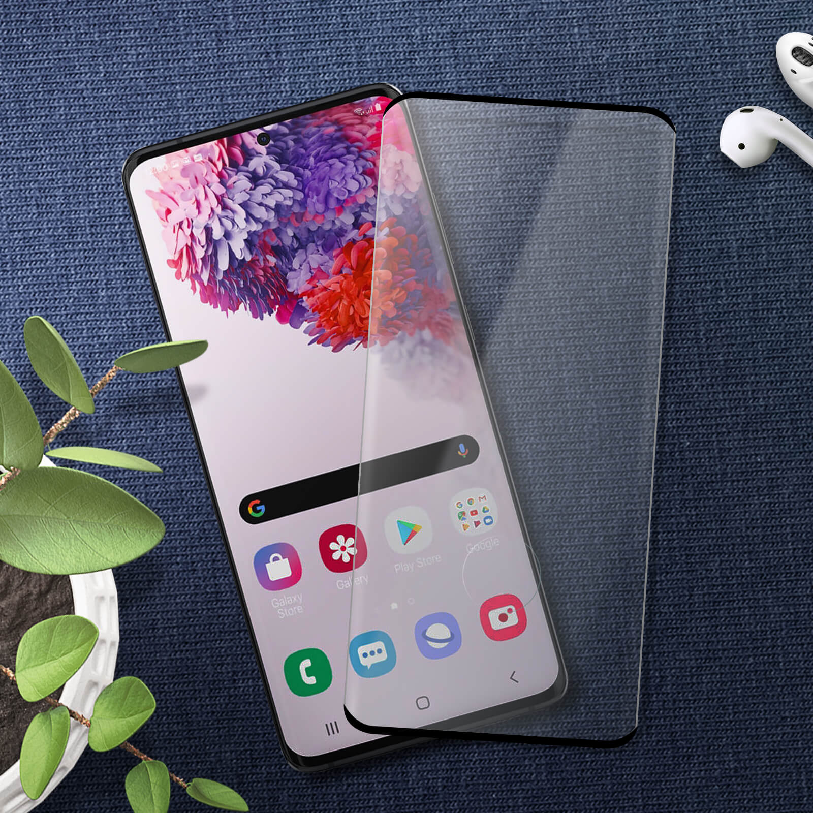 Telefono con protezione schermo. Schermo mostra app. Sfondo denim blu. Auricolari bianchi.
