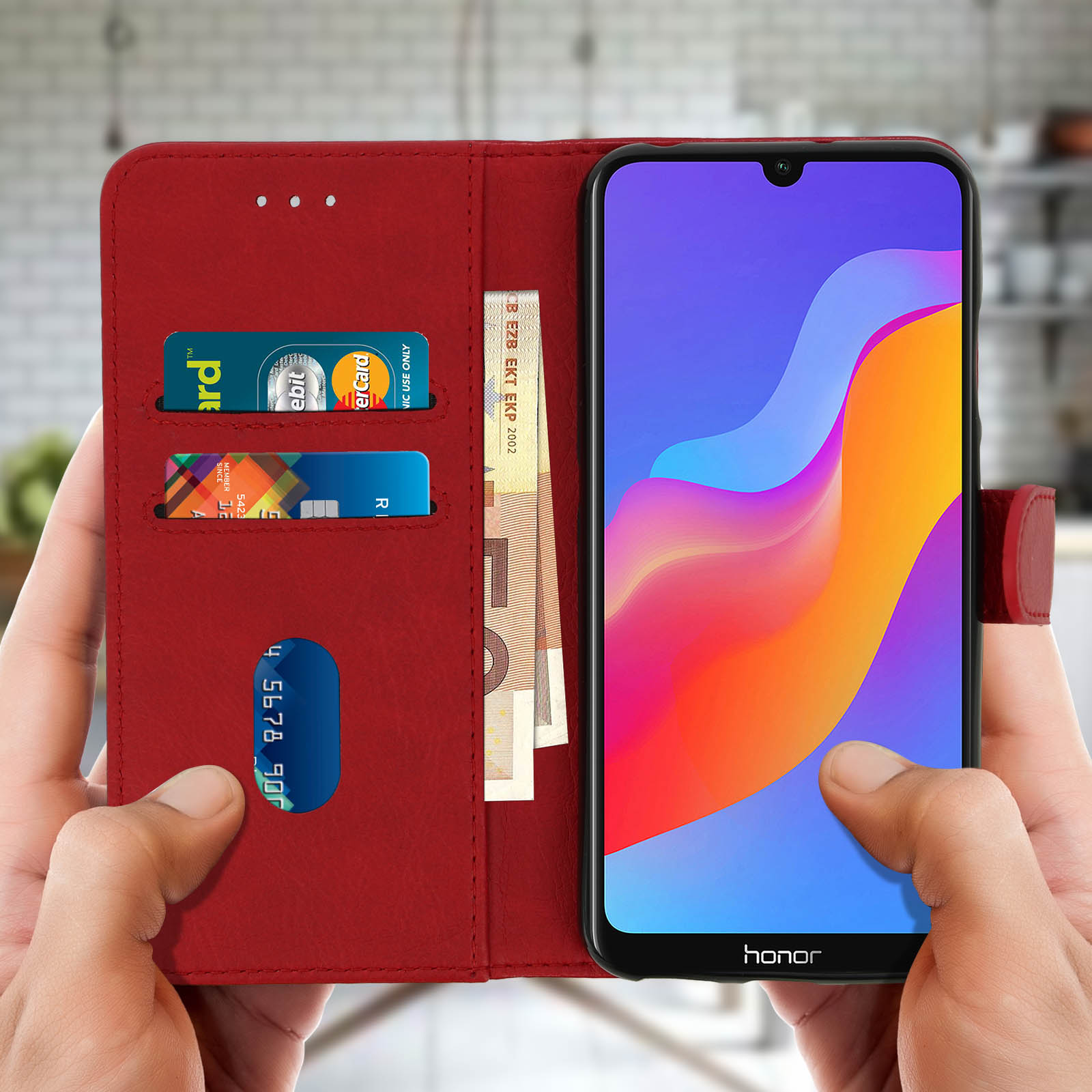Una custodia per telefono rossa che tiene un telefono aperto, rivelando carte e denaro. Tenuta da due mani.