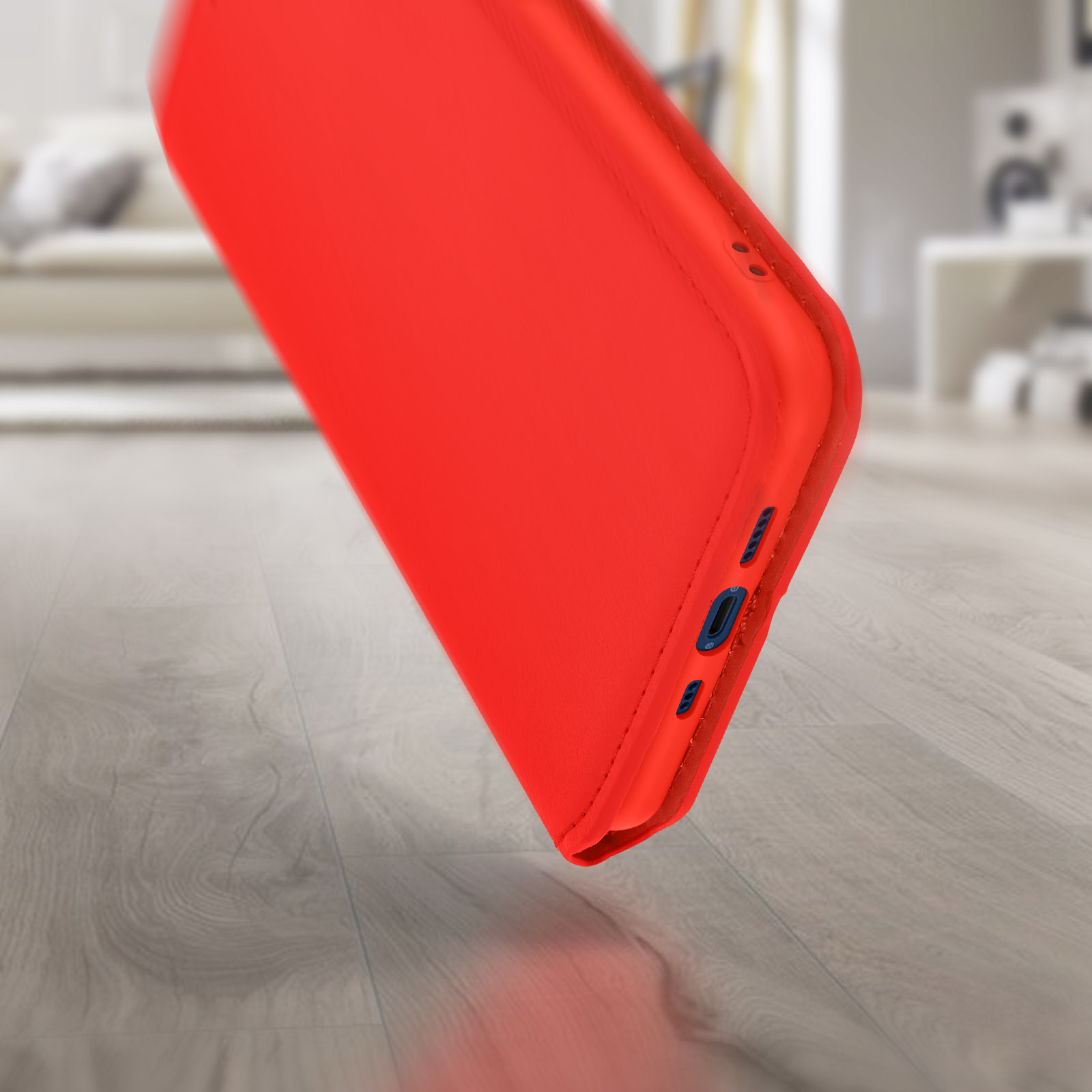 Een rode telefoonhoes is schuin, met zijknoppen. De achtergrond is een vage houten vloer.