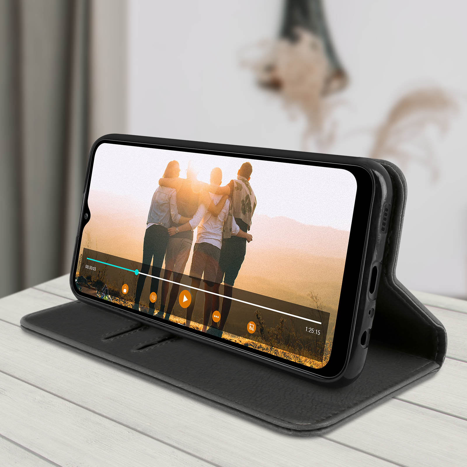 Un telefono in una custodia che mostra un video di un gruppo di persone. La custodia è grigio scuro.