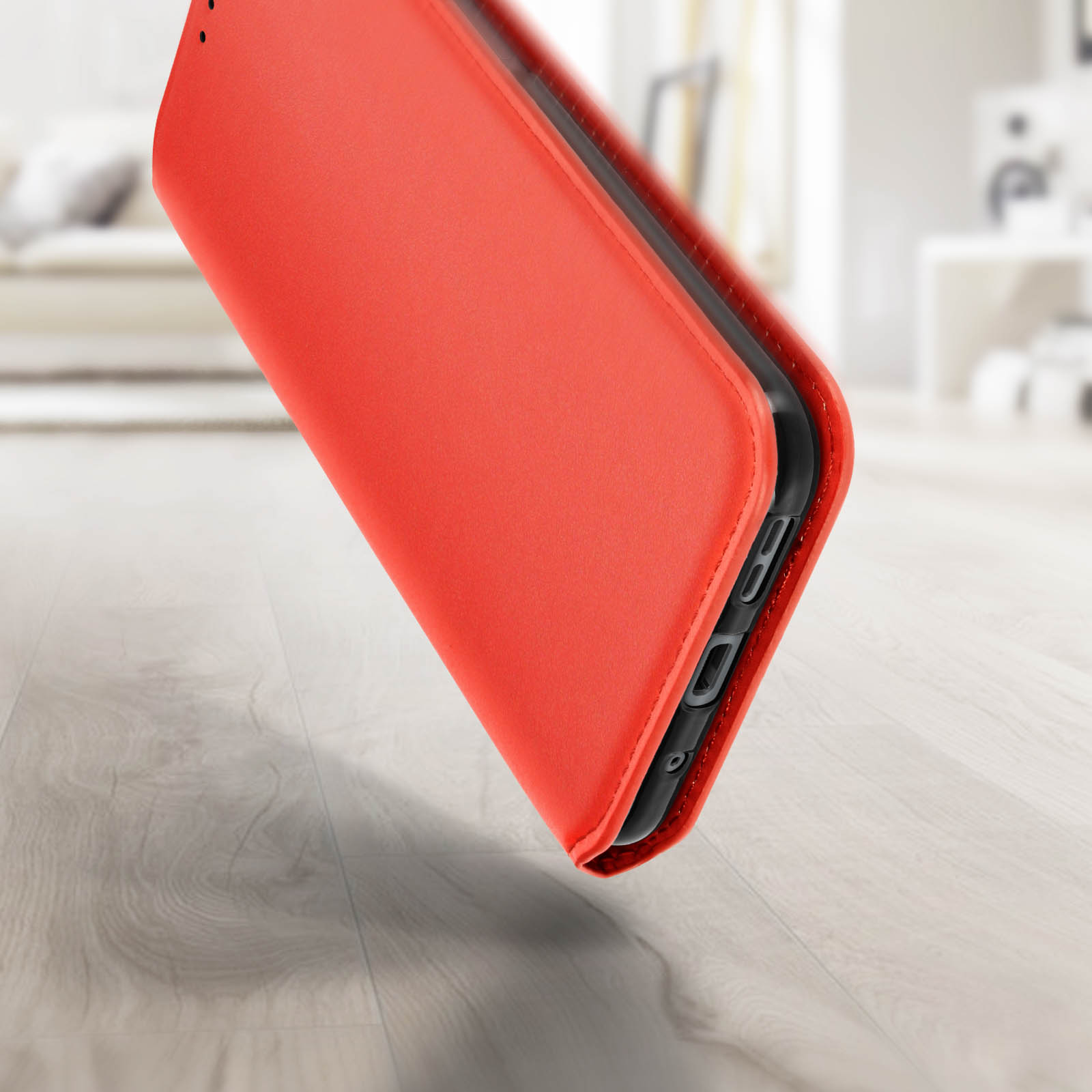 Custodia rossa per telefono con telefono all'interno, su una superficie in legno. Sfondo sfocato.