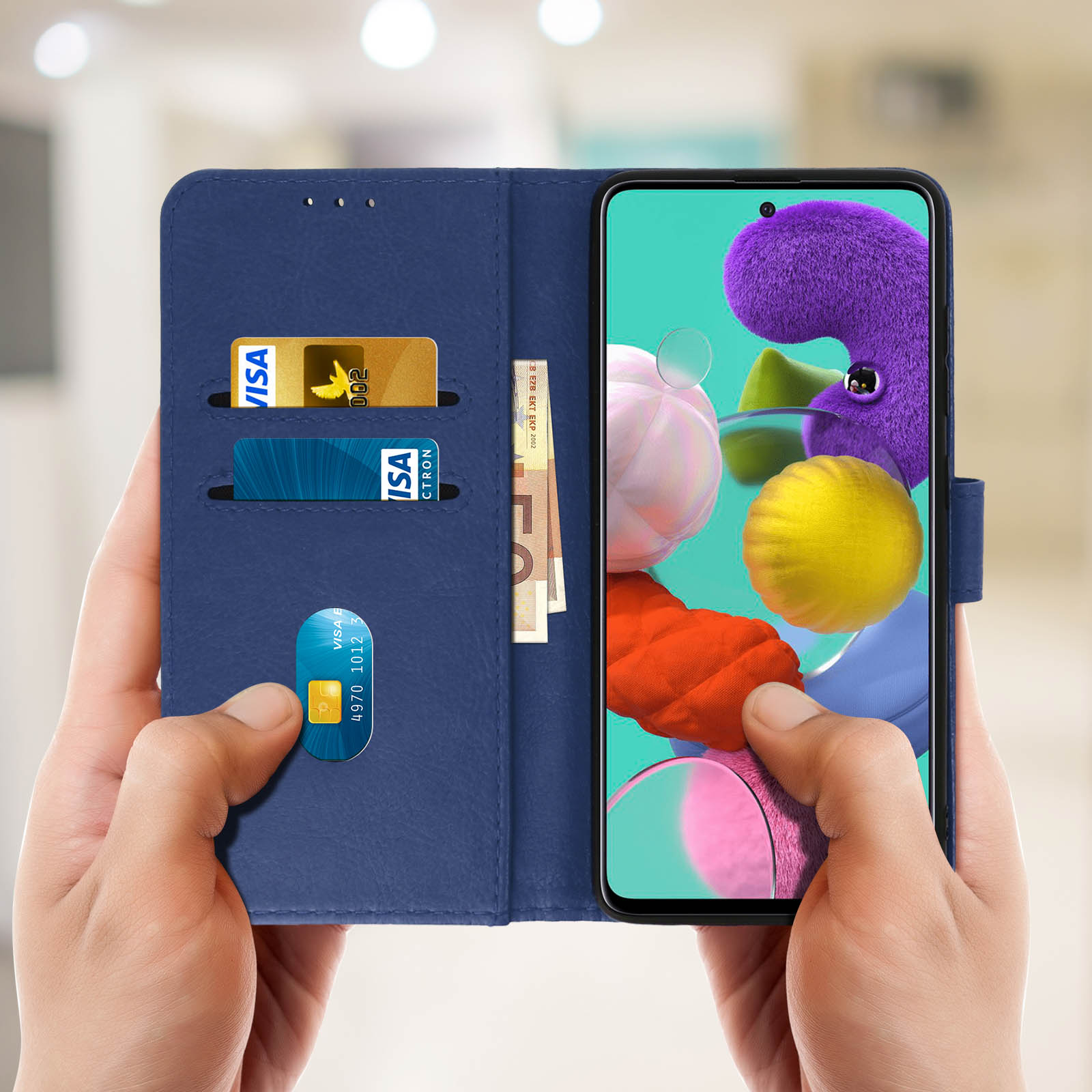 Handen die een blauwe leren telefoonhoes openhouden, met daarin een telefoon, kaarten en geld.