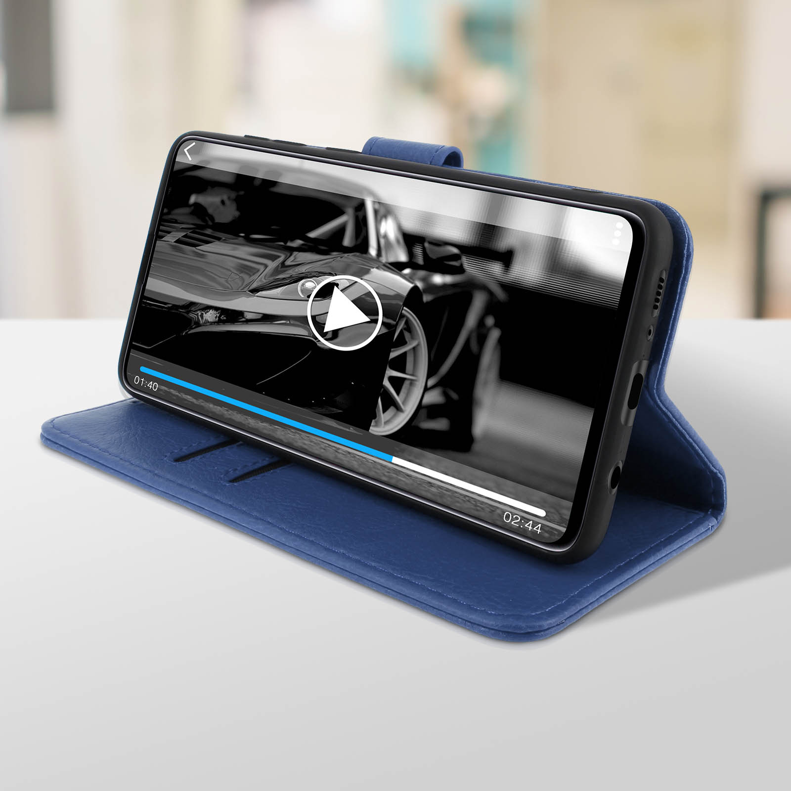 Een telefoon in een blauwe hoes die een video van een auto afspeelt. De hoes is open.