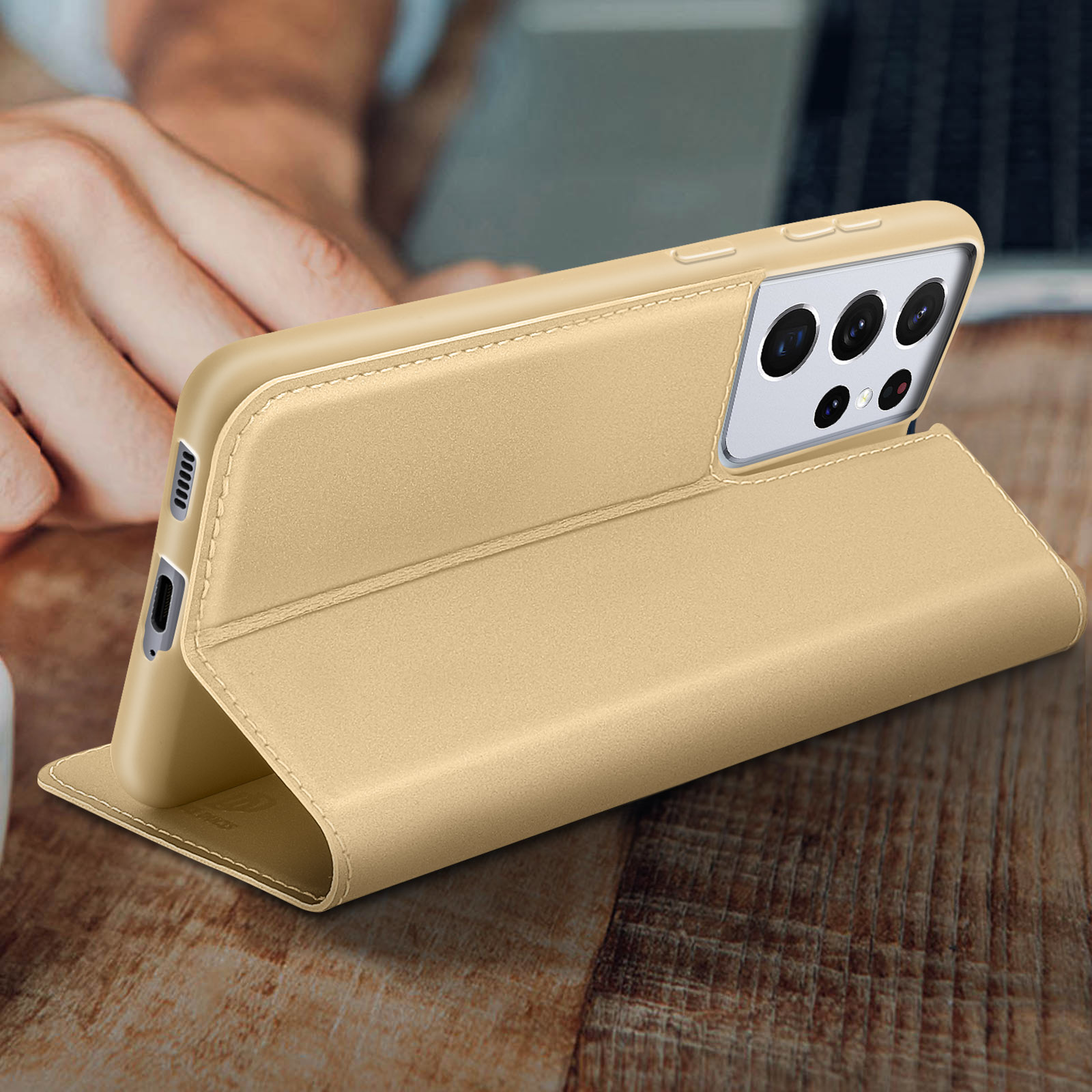 Custodia dorata per telefono con telefono su superficie in legno. La custodia è aperta.