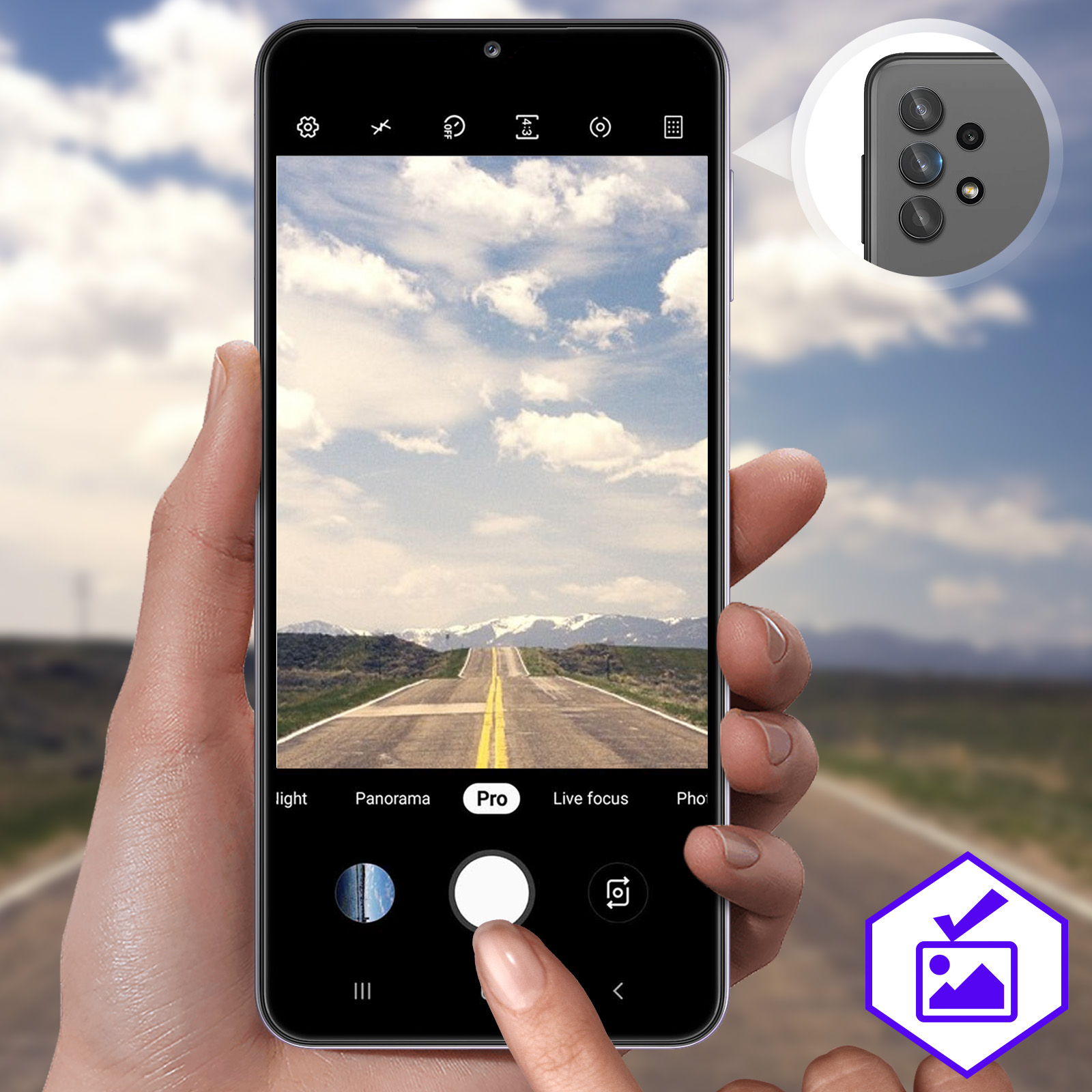 Main tenant un smartphone prenant une photo d'une route. Le fond montre le ciel et le paysage.