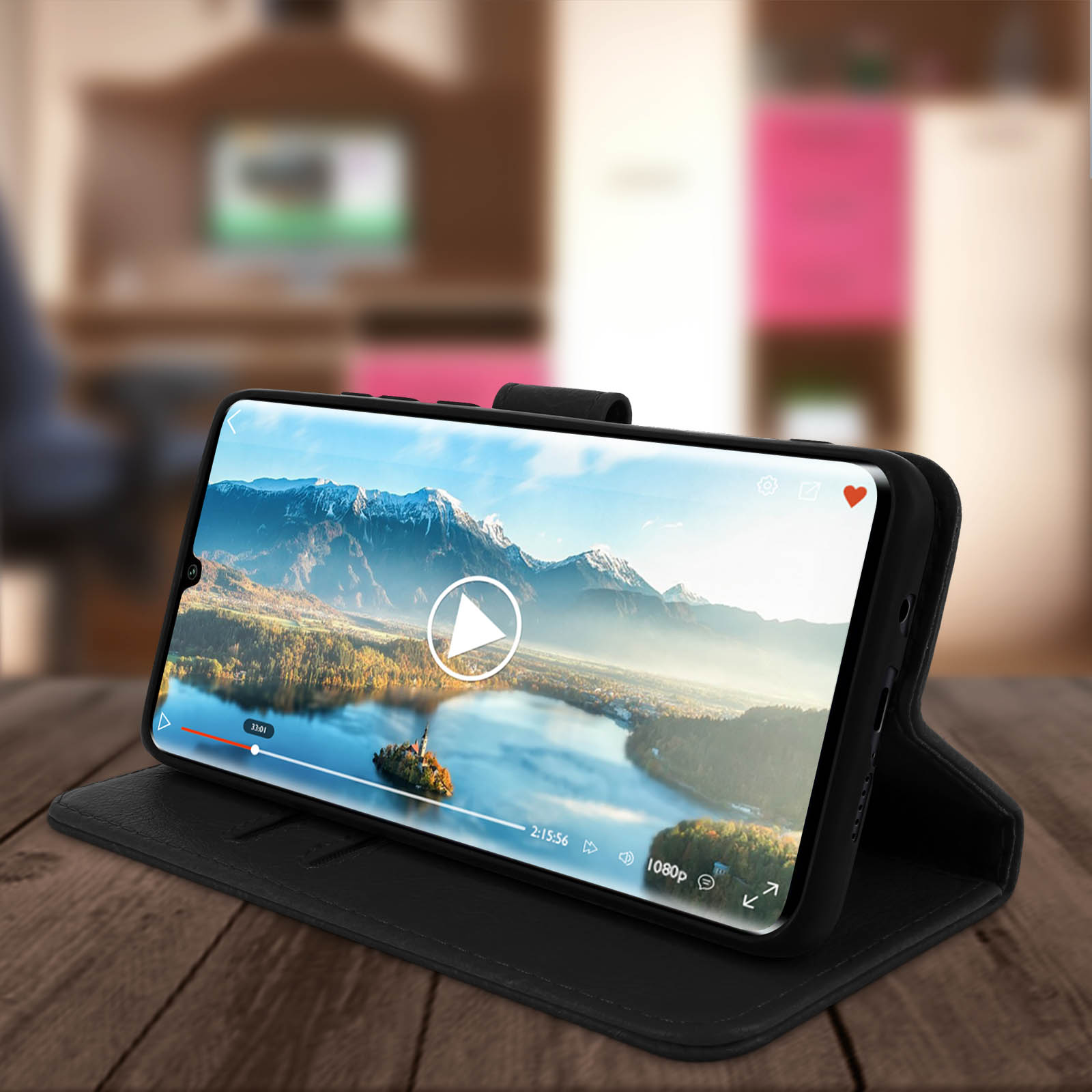 Un téléphone noir affiche une vidéo sur une table en bois avec un arrière-plan flou.