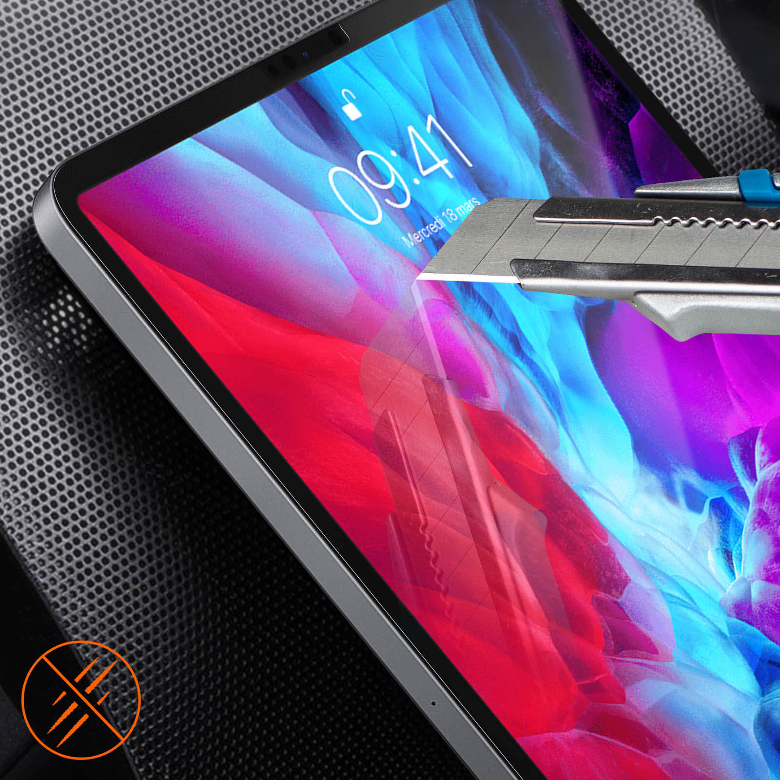 Een mes snijdt een schermbeschermer op een tablet. De tablet ligt op een donkere ondergrond.
