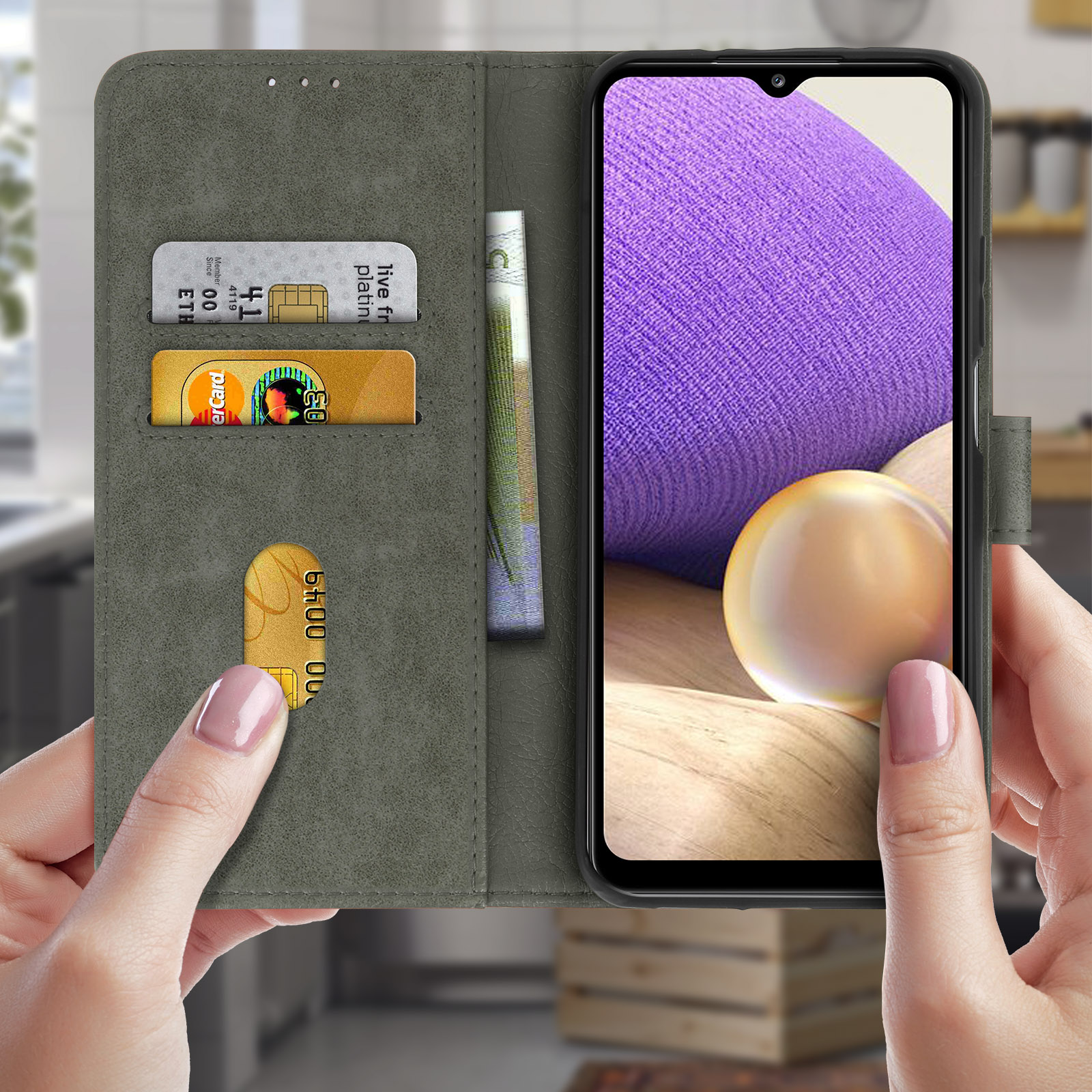 Offenes Handycase mit Telefon, Karten und Geld. Gehalten von Händen, Telefon zeigt Bild.