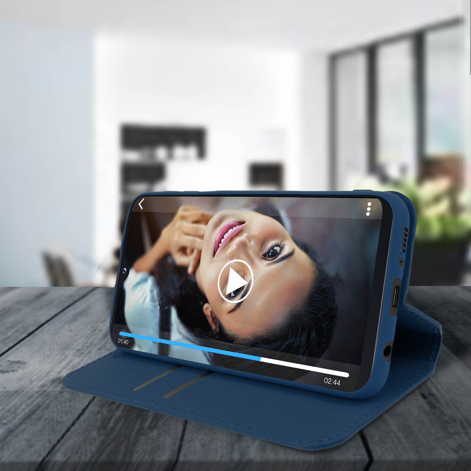 Telefoon in een blauwe hoes. Een vrouw op het scherm, speelt een video af.