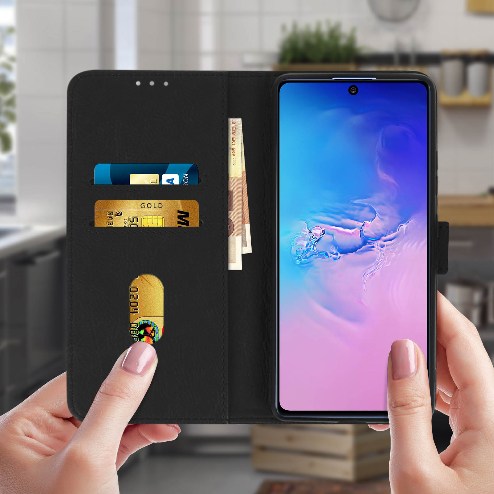 Custodia nera con carte, denaro e un telefono in mano.