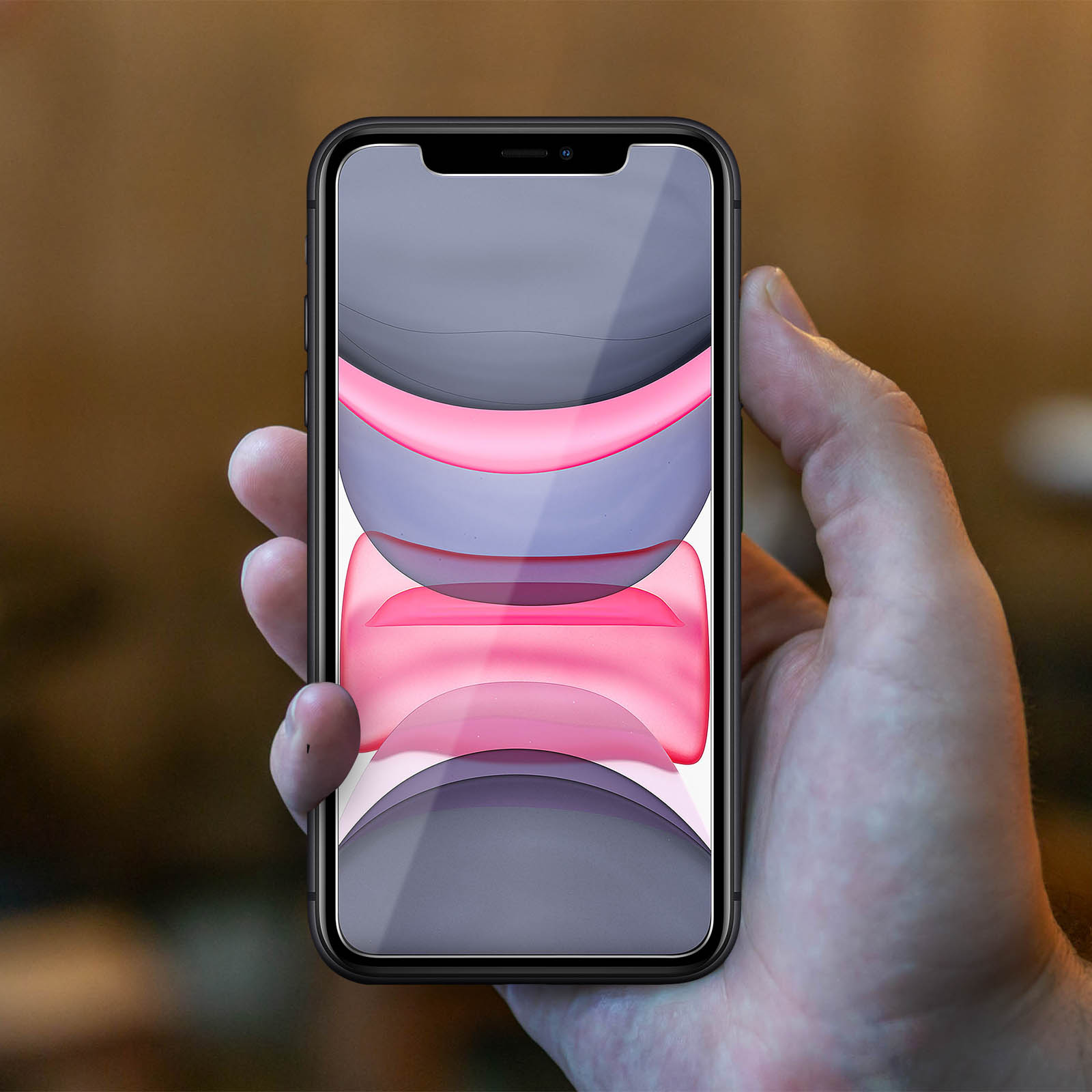 A hand holds a phone with a screen displaying a colorful image.