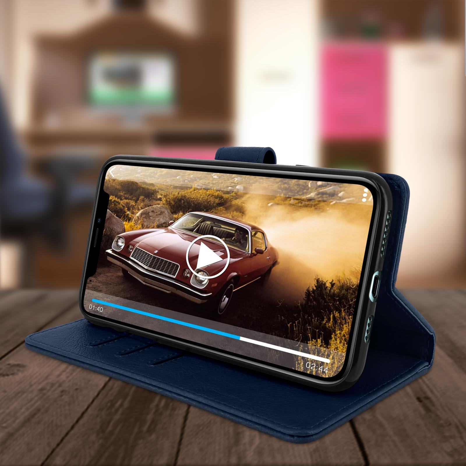 Téléphone dans un étui bleu, affichant une vidéo de course-poursuite. Table en bois avec arrière-plan flou.