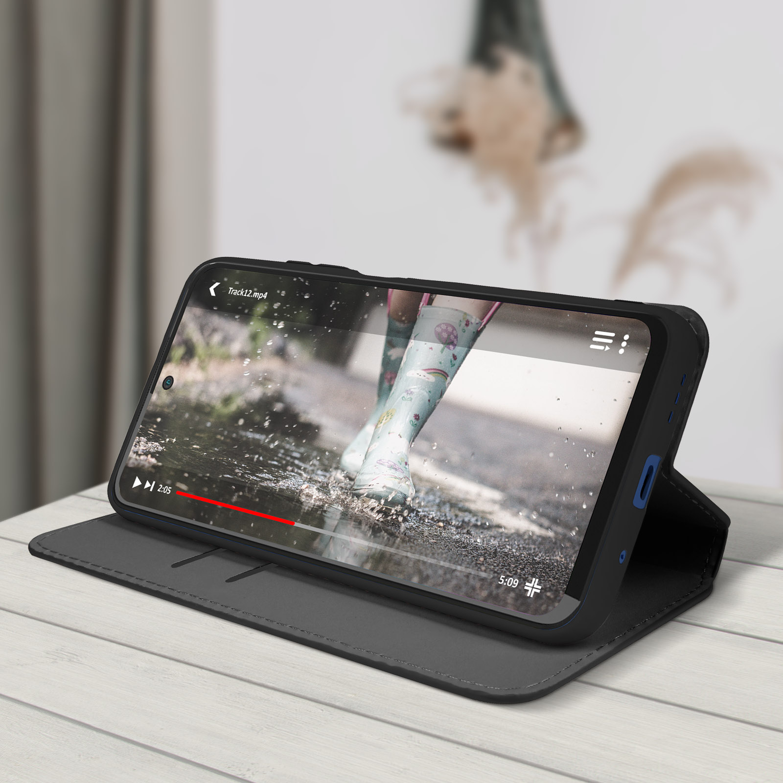 Een telefoon met hoesje is open en toont een video van een persoon in het water. Op een houten tafel.