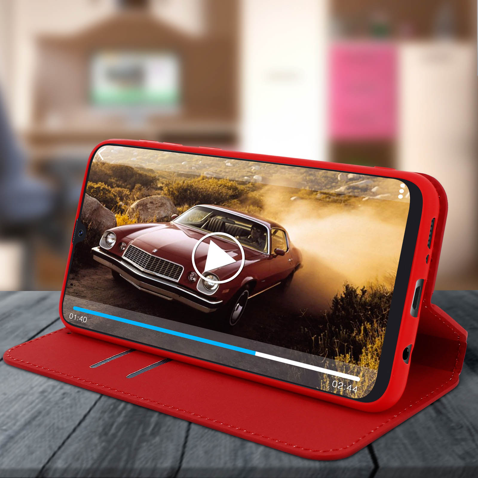 Custodia rossa per telefono che mostra un video di un'auto d'epoca su un tavolo di legno.