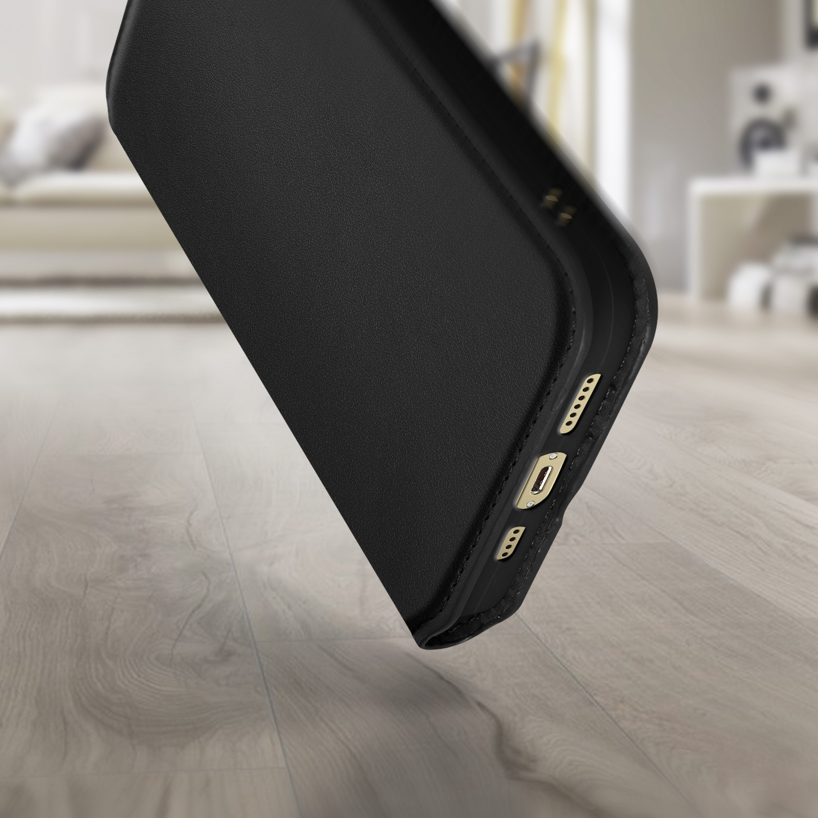 Close-up van een zwarte telefoonhoes. De telefoonhoes ligt op een houten oppervlak.