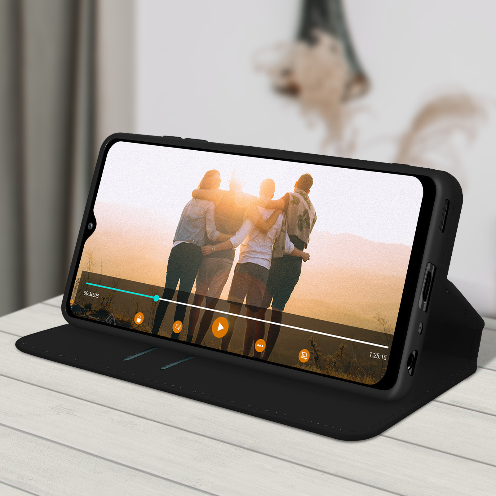 Un téléphone dans un étui noir affichant une vidéo sur l'écran. La vidéo montre des personnes s'embrassant.