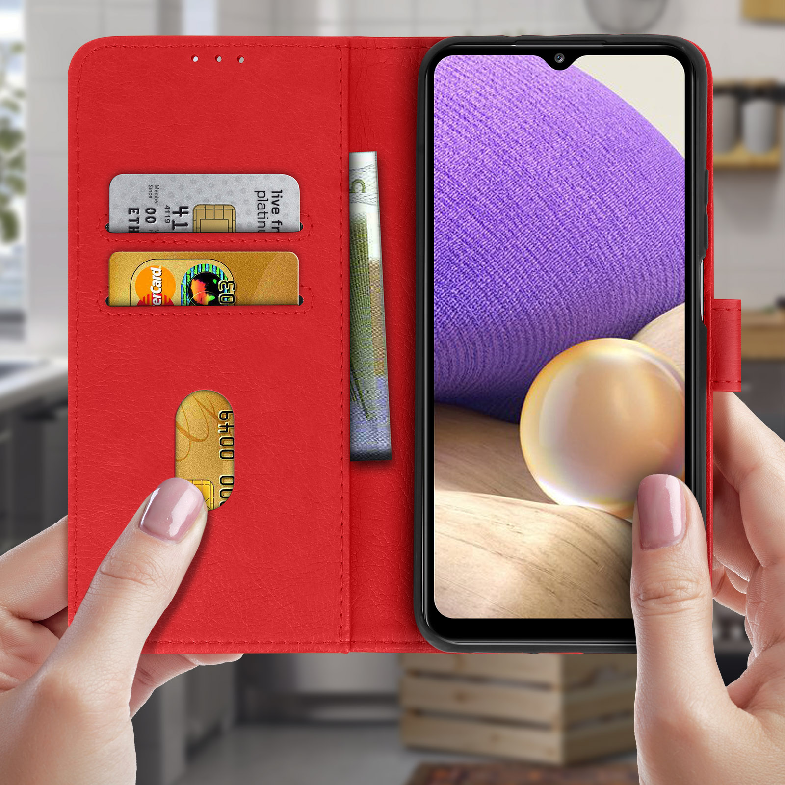 Custodia rossa per telefono. All'interno, ci sono un telefono, carte e contanti. Lo sfondo è una cucina.