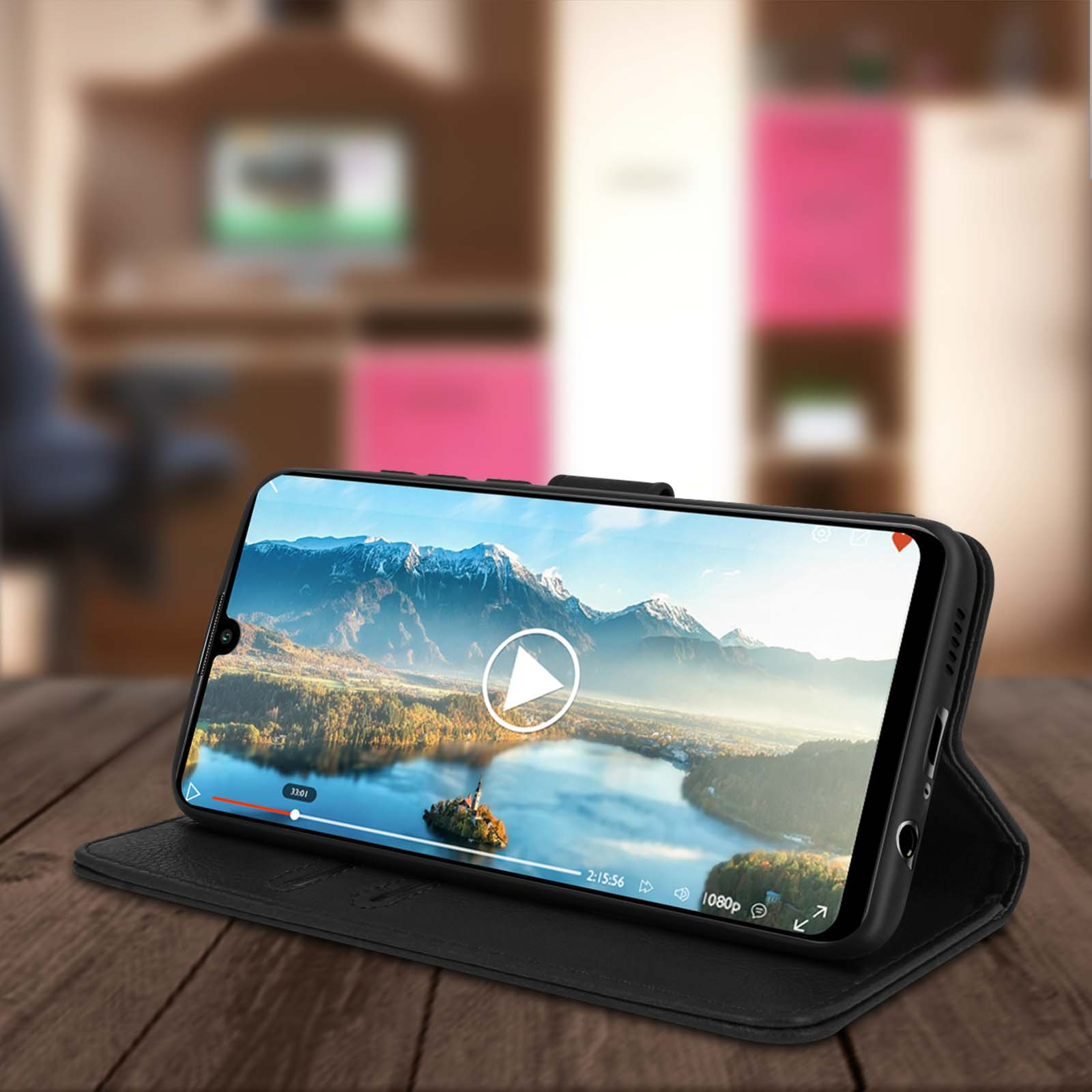 Un téléphone sur un support affichant une vidéo. Le support est sur une surface en bois.