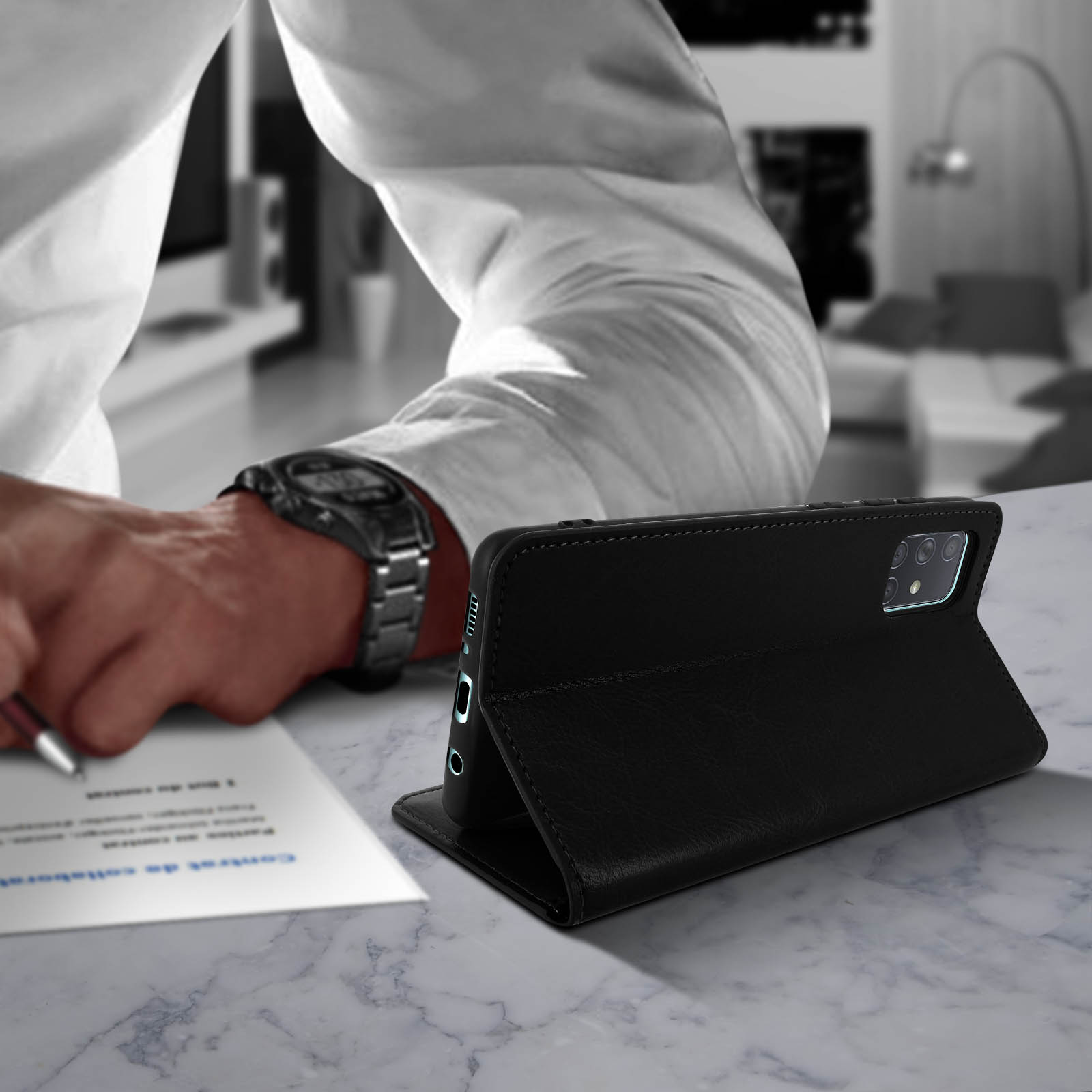 Persona che scrive su un documento con custodia. La custodia è aperta sul tavolo.