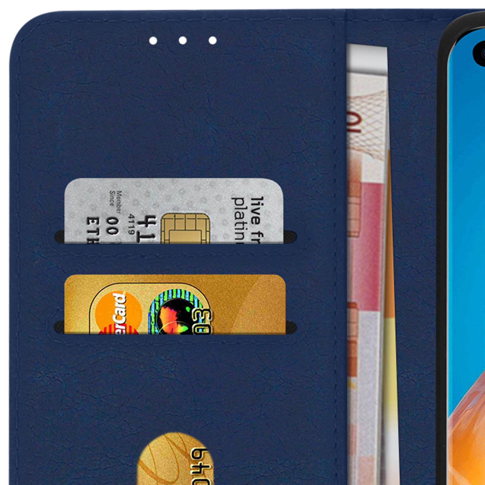 Custodia blu navy, un telefono, carte e contanti visibili all'interno. Lo sfondo è sfocato.