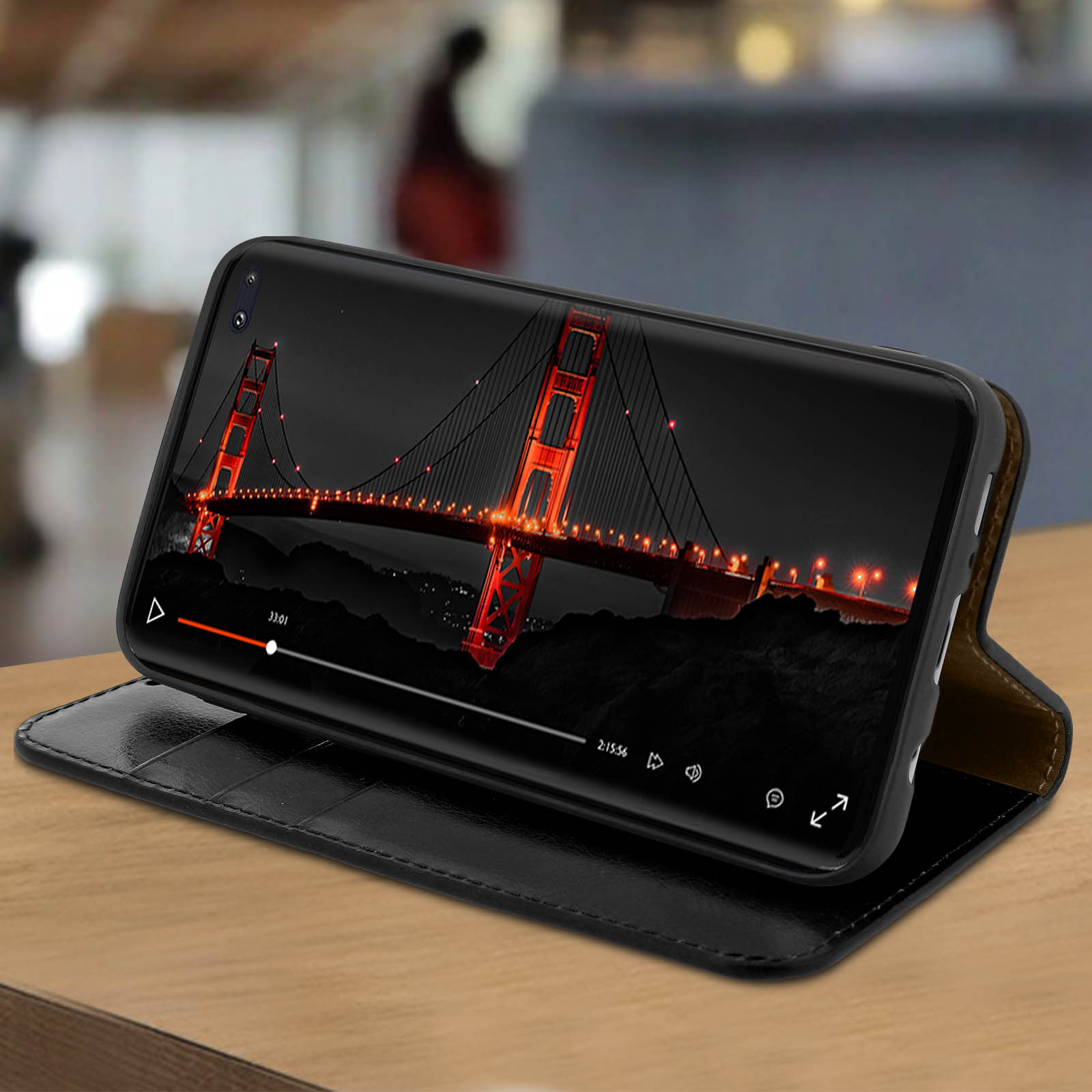 Un telefono in una custodia nera che mostra un video del Golden Gate Bridge di notte. La custodia è aperta.