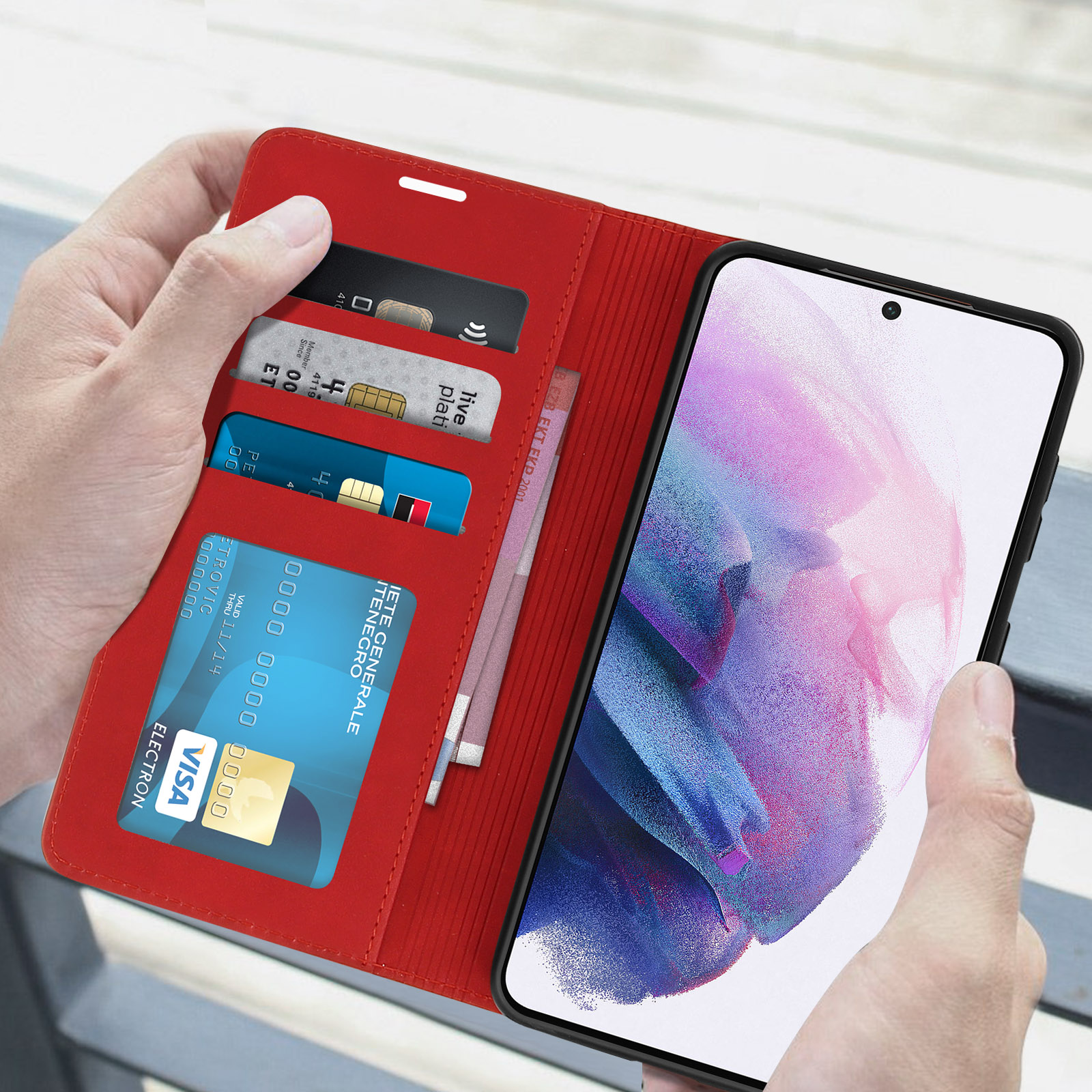 Custodia rossa, aperta, fessure per carte, denaro, telefono nella custodia, mani che lo tengono.