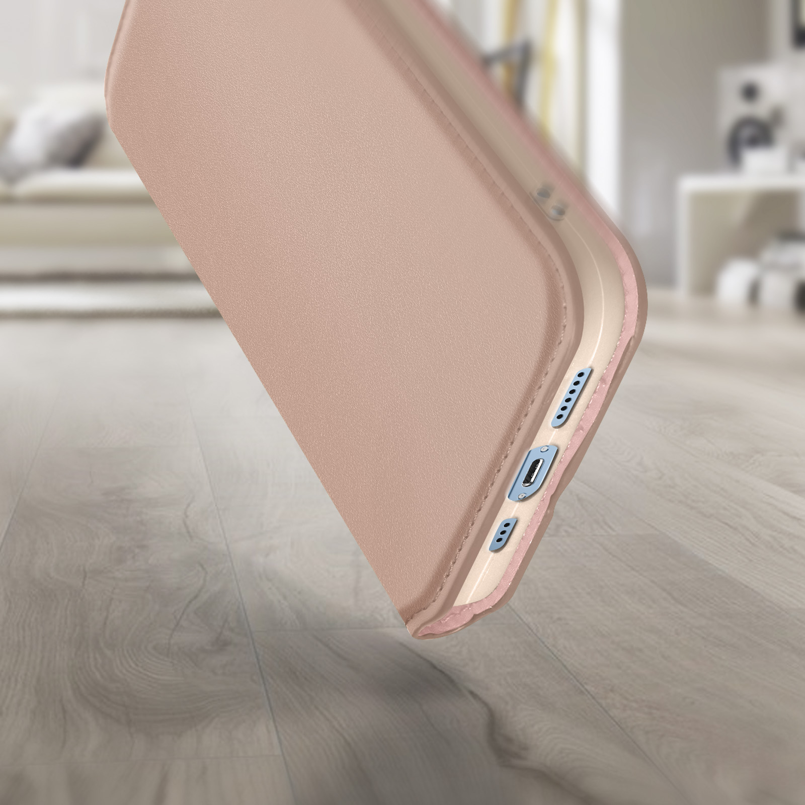 Close-up van een telefoonhoesje, zachtroze buitenkant, lichtroze binnenkant en knoppen.