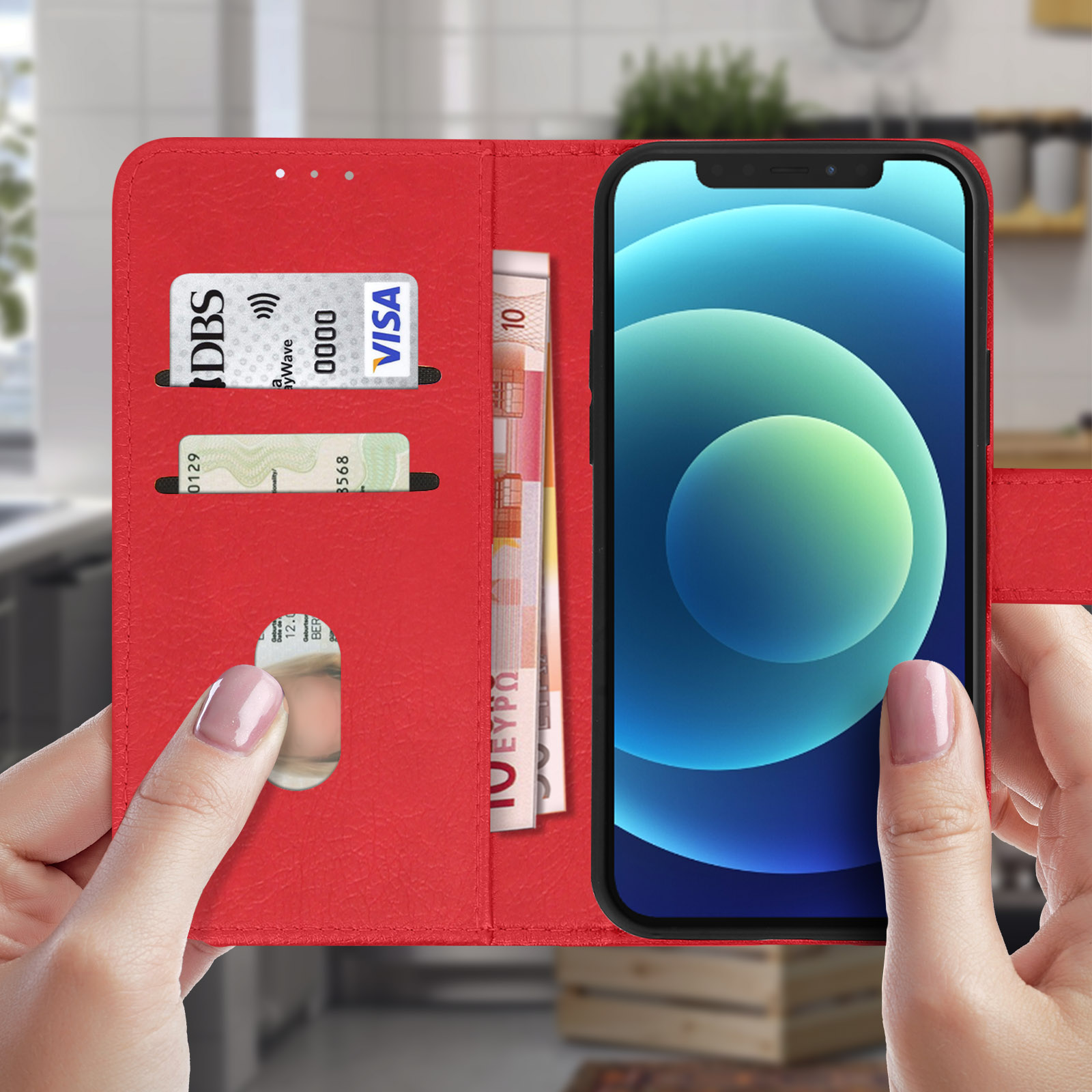 Étui de téléphone rouge ouvert avec des fentes pour cartes et de l'argent. Le téléphone est à l'intérieur. Mains le tenant.