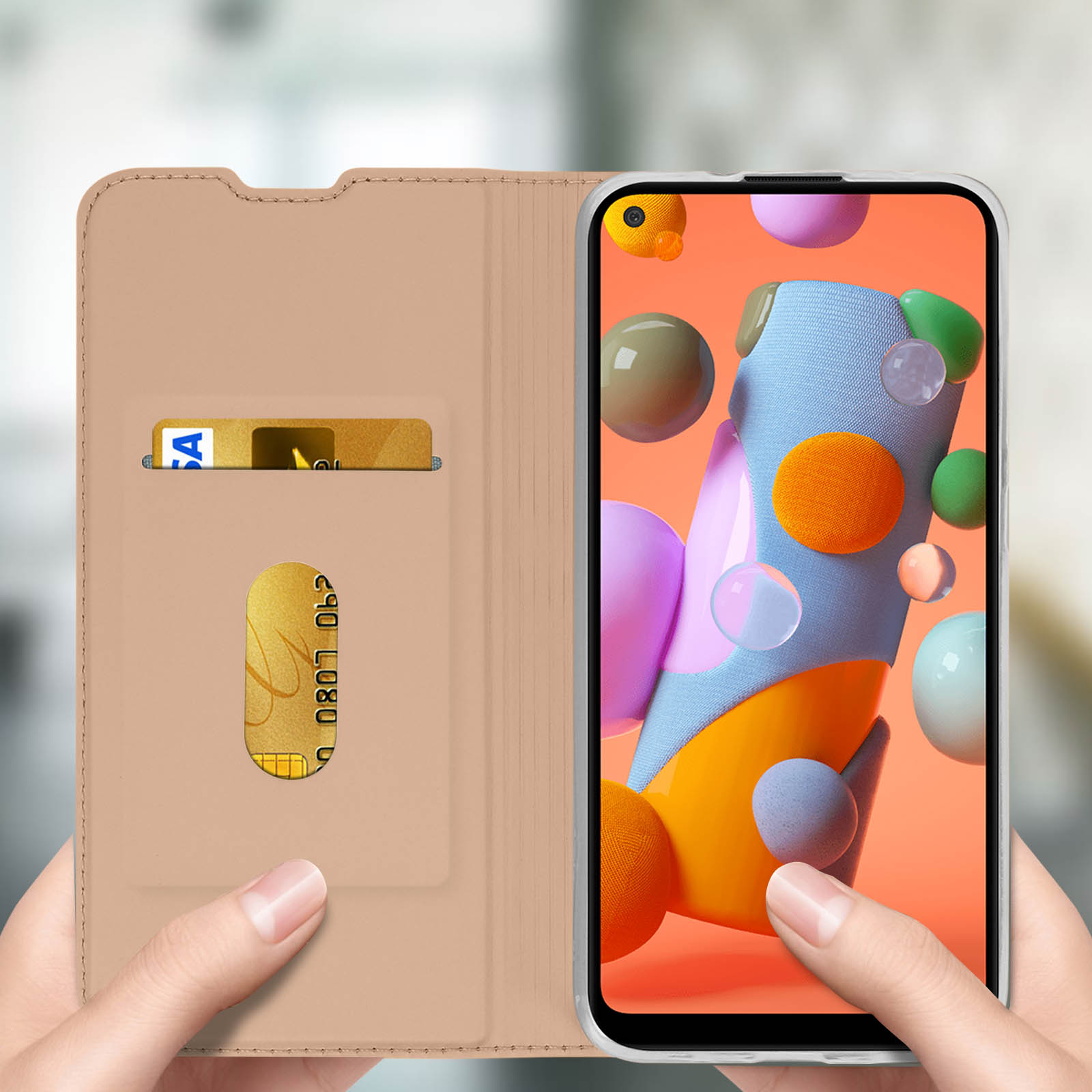Un telefono in una custodia che mostra forme astratte colorate, con una carta e mani che lo tengono.