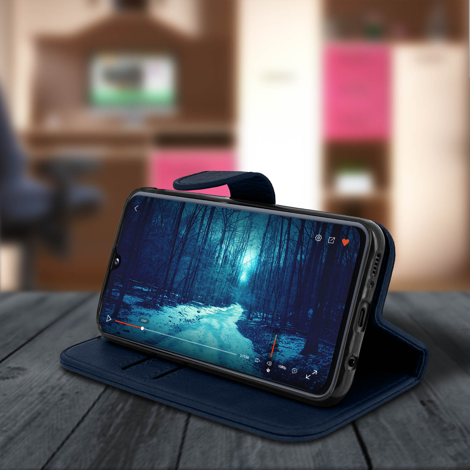 Telefoon toont video op tafel. Video toont bospad. Telefoon in blauwe hoes.