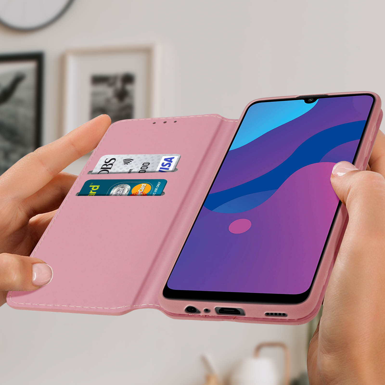 Un teléfono en una funda rosa, abierto con tarjetas en el soporte.