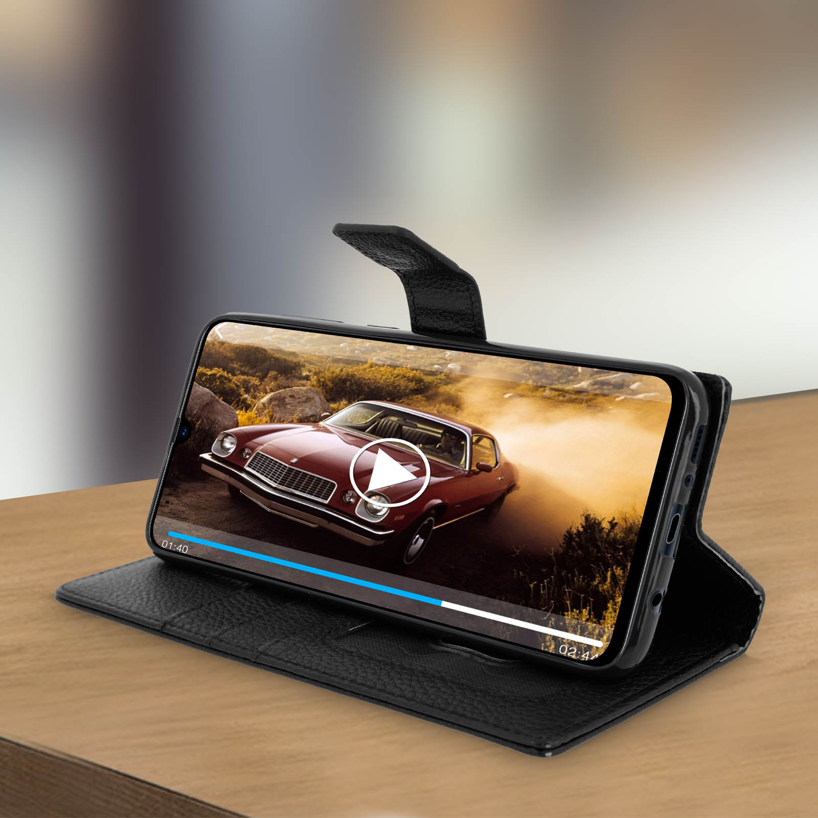 Un téléphone dans un étui montrant une vidéo de voiture sur une table en bois.