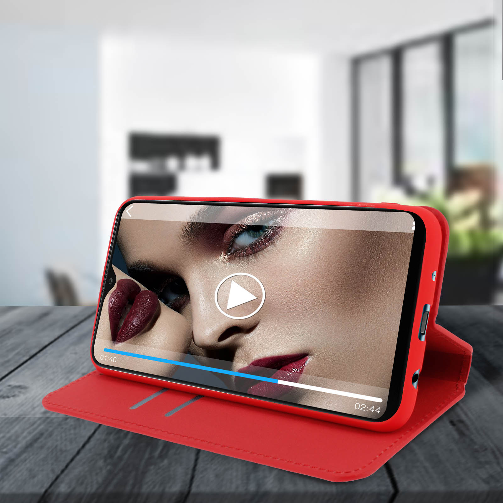 Een rode telefoon in een rode hoes toont het gezicht van een vrouw met rode lippenstift. Een afspeelknop is zichtbaar.
