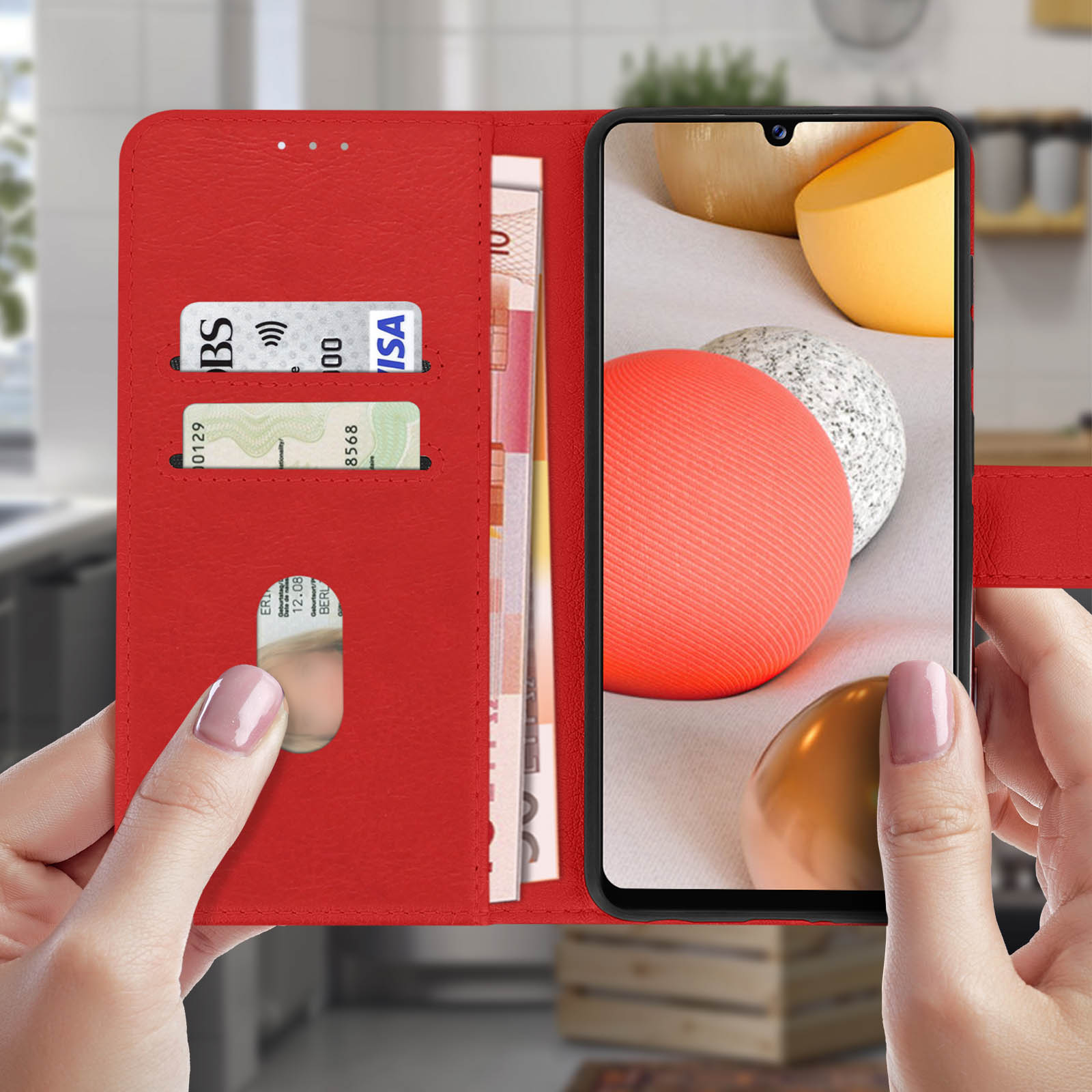 Custodia rossa con telefono, carte di credito e contanti visibili, tenuta da due mani.