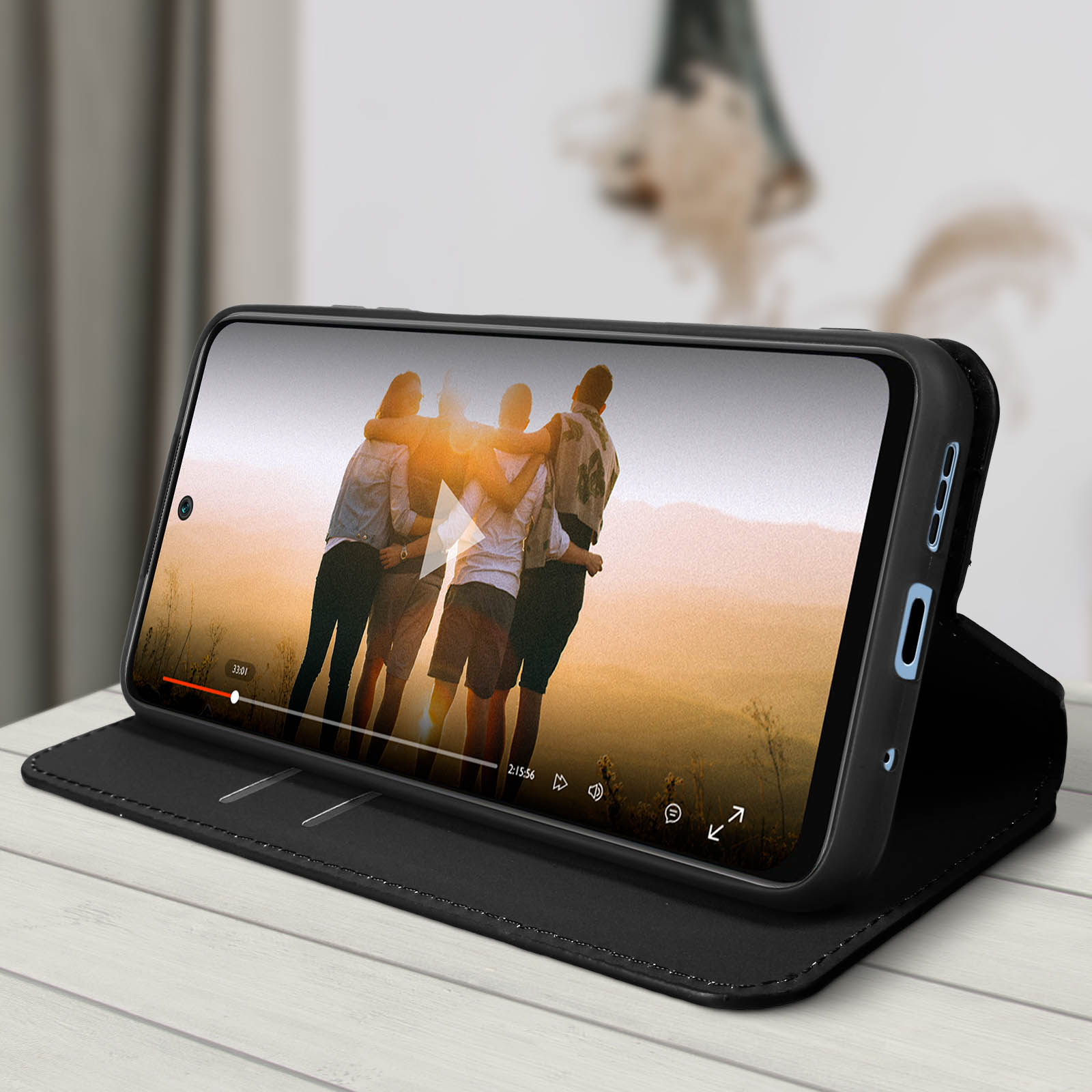 Téléphone dans un étui montrant une vidéo sur une table.