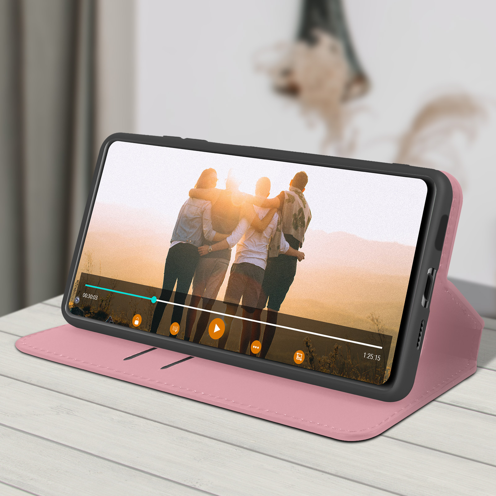Telefono in custodia, appoggiato per guardare un video. Lo sfondo è un soggiorno sfocato.