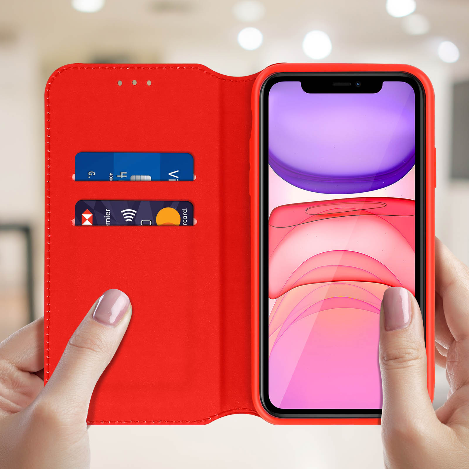 Una persona che tiene una custodia rossa aperta con carte di credito all'interno.