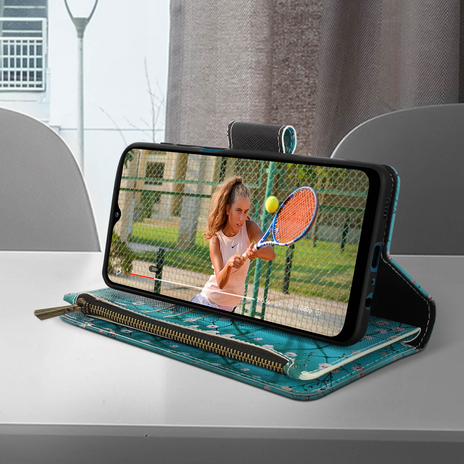 Uno smartphone con un video di tennis in riproduzione. Il telefono è in una custodia, su una superficie a motivi.