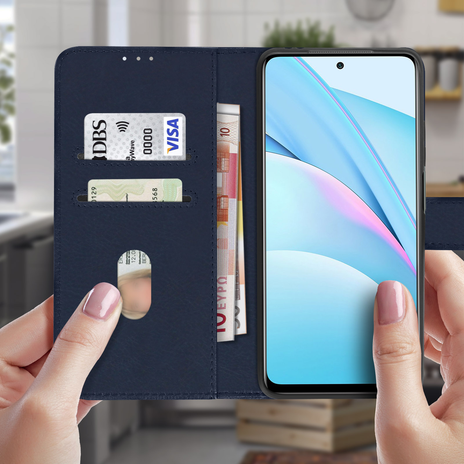 Mani che tengono custodia in pelle blu con carte e denaro, schermo del telefono visibile.