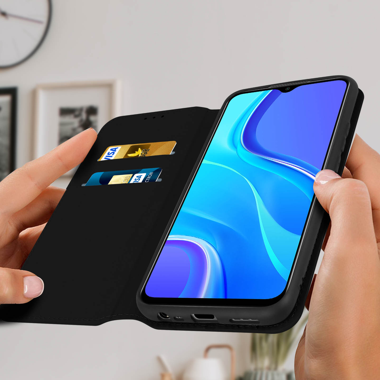 Mains tenant un étui de téléphone noir ouvert, avec un téléphone à l'intérieur. Deux cartes dans l'étui.