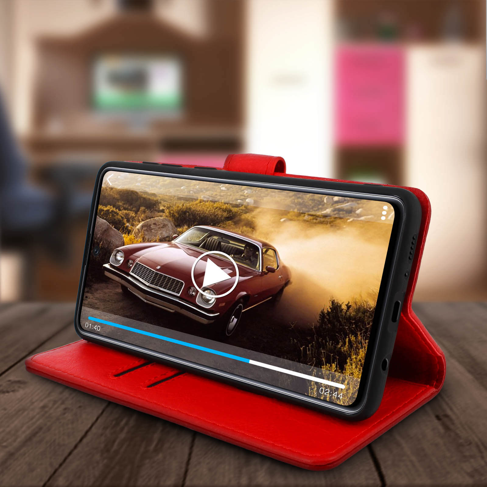 Étui de téléphone rouge avec trois fentes. Une fente a une carte. Téléphone diffusant une vidéo de voiture.