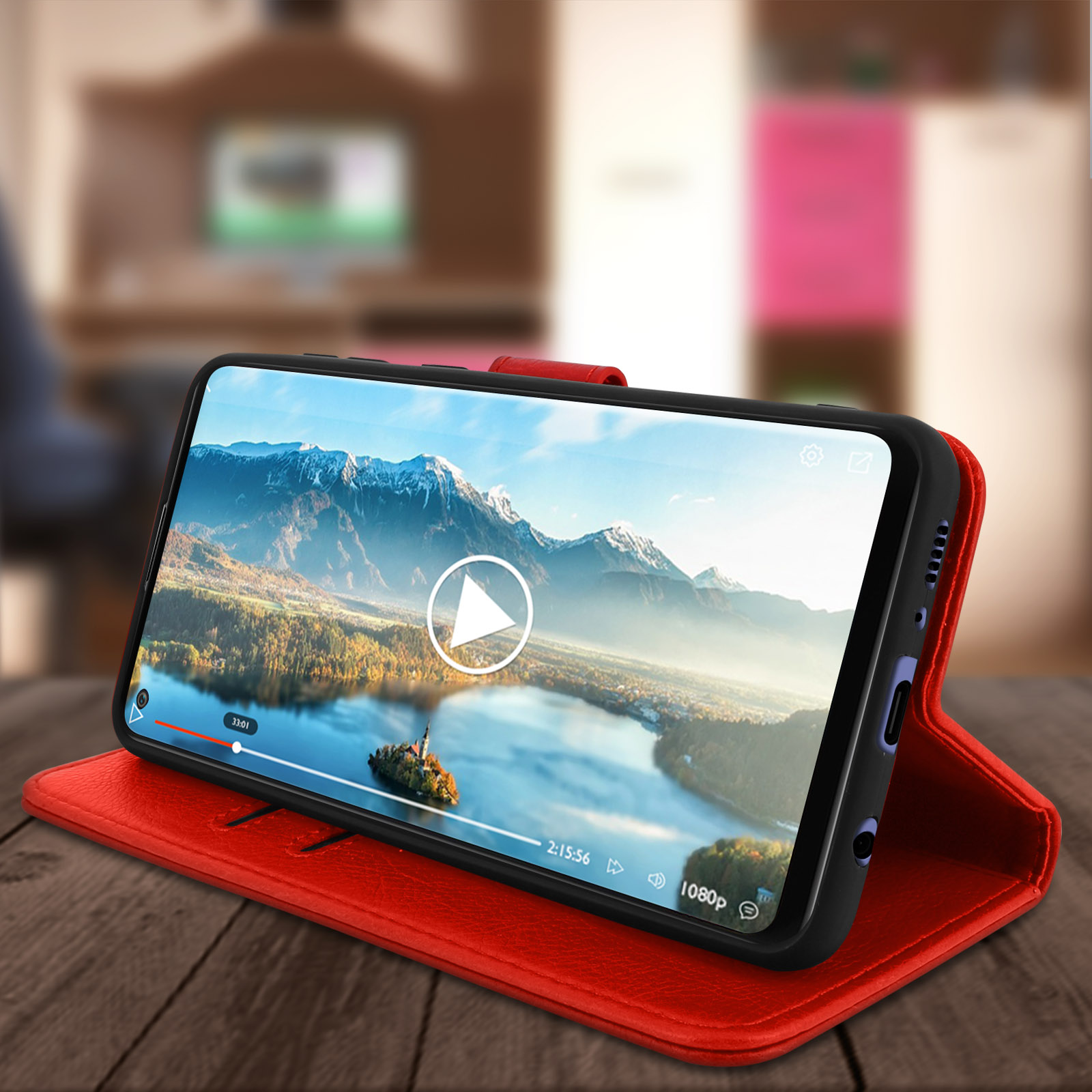 Étui de téléphone rouge avec un téléphone affichant une vidéo. Le téléphone est sur une surface en bois. L'arrière-plan est flou.