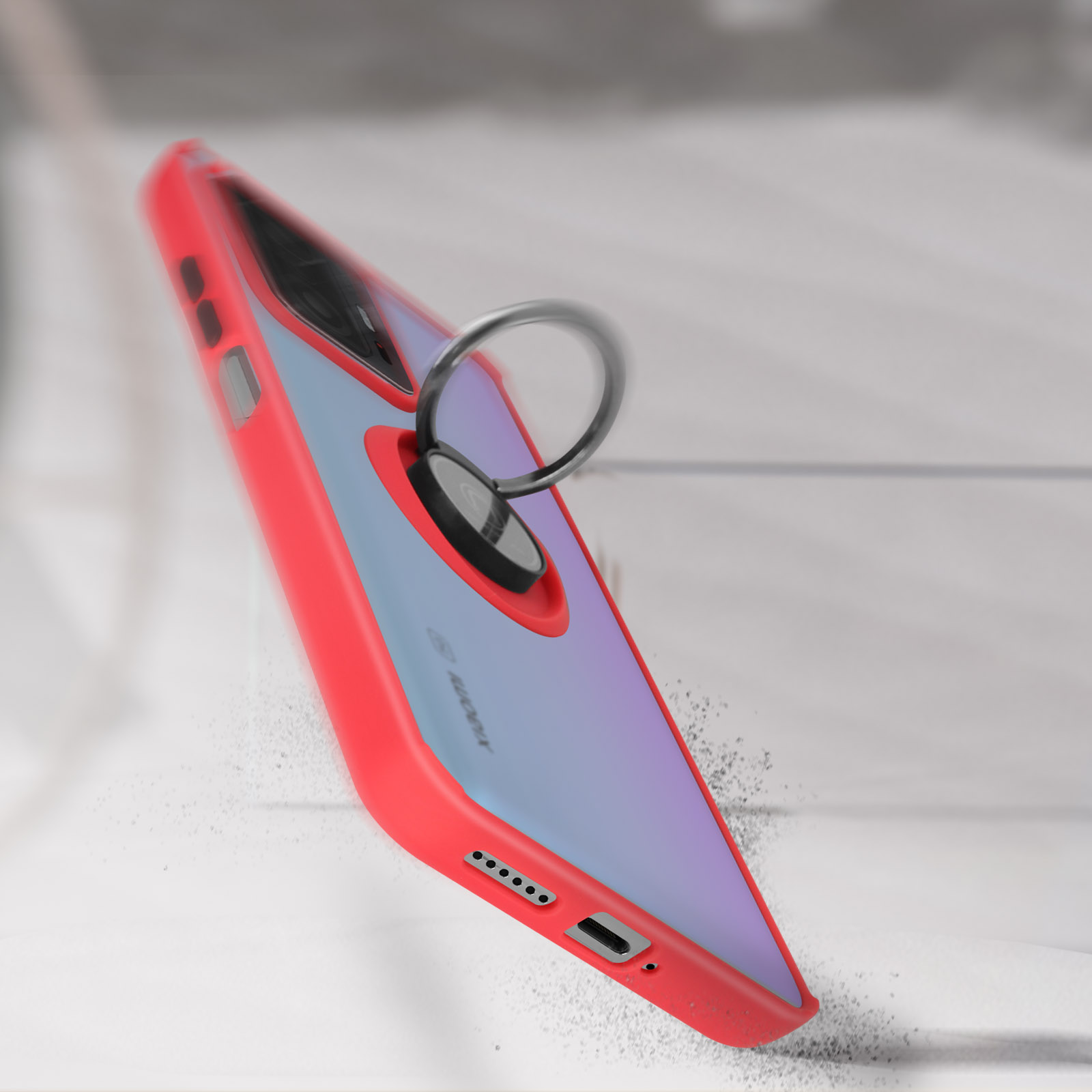 Una custodia per telefono rossa e blu con un supporto ad anello. Lo sfondo è una superficie chiara e sfocata. Effetto caduta.